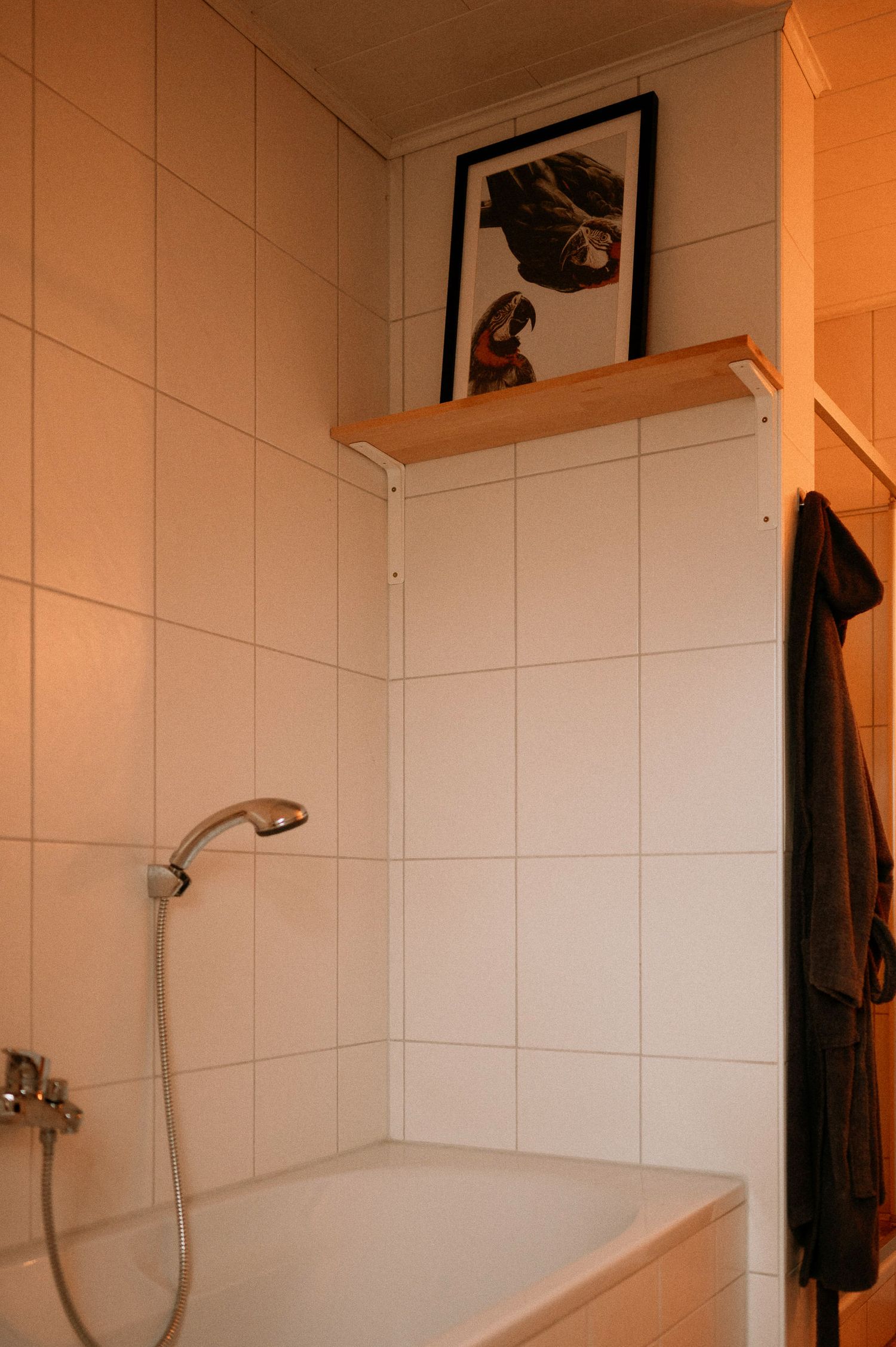 White tiled bathroom interior with minimal decor and natural lighting.