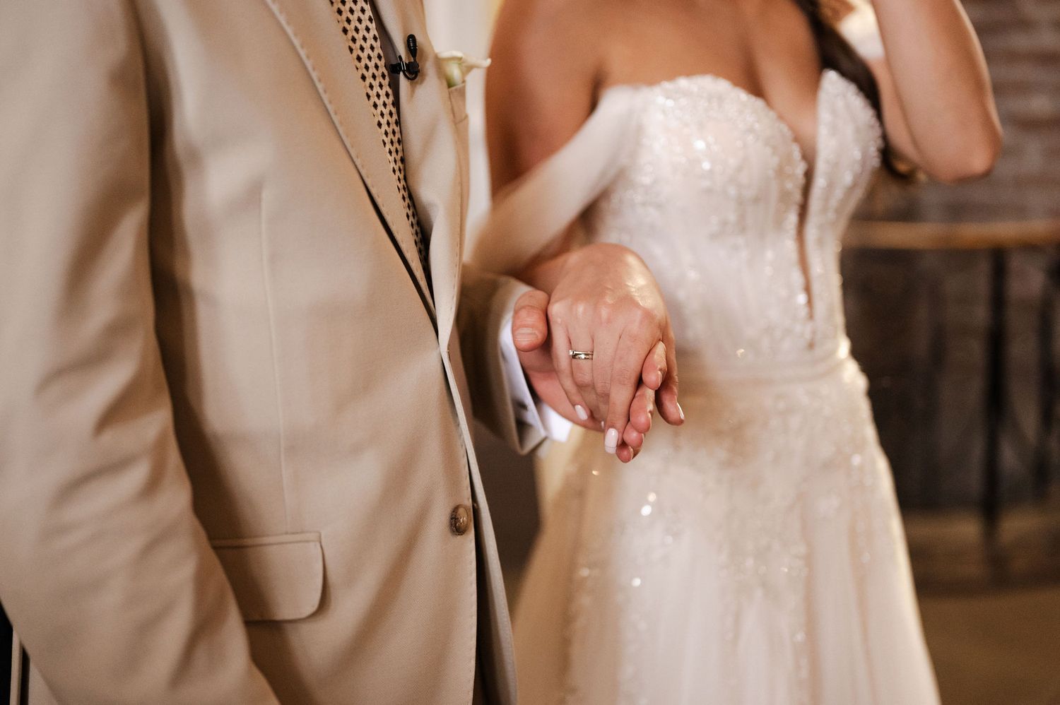 Intimate wedding portraits showing couple in cream and white attire against brick walls.