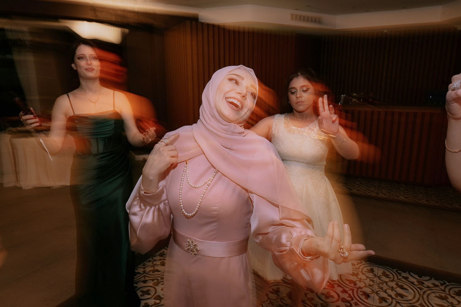 Guests dancing and celebrating in formal attire at an evening reception.