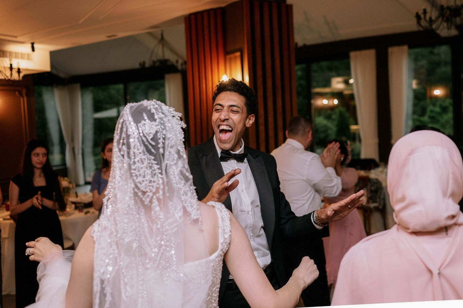 Wedding reception dance party in progress with elegant interior lighting and decor.