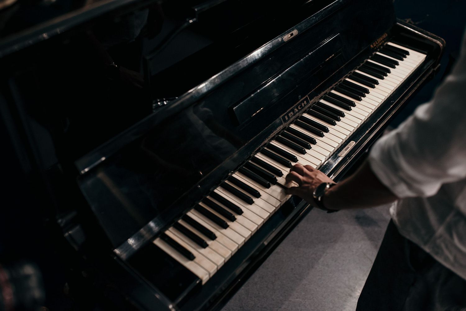 Close-up view of black piano keys in dramatic lighting showing musical instrument details.