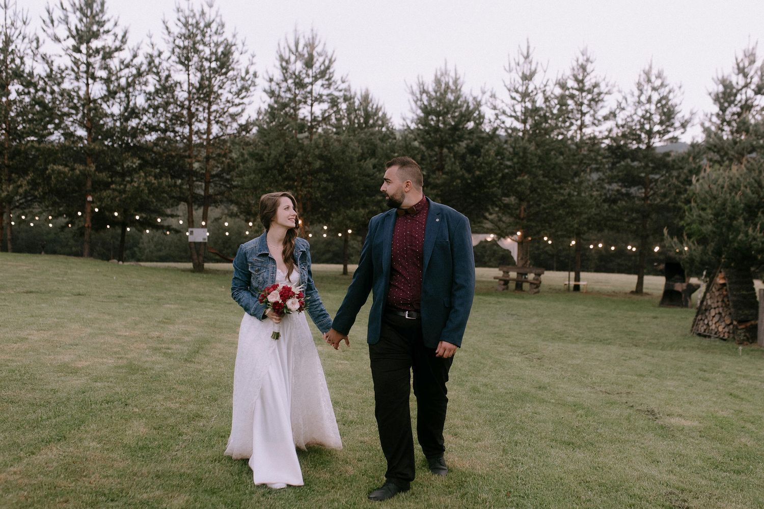 Wedding party walking through scenic pine forest setting.