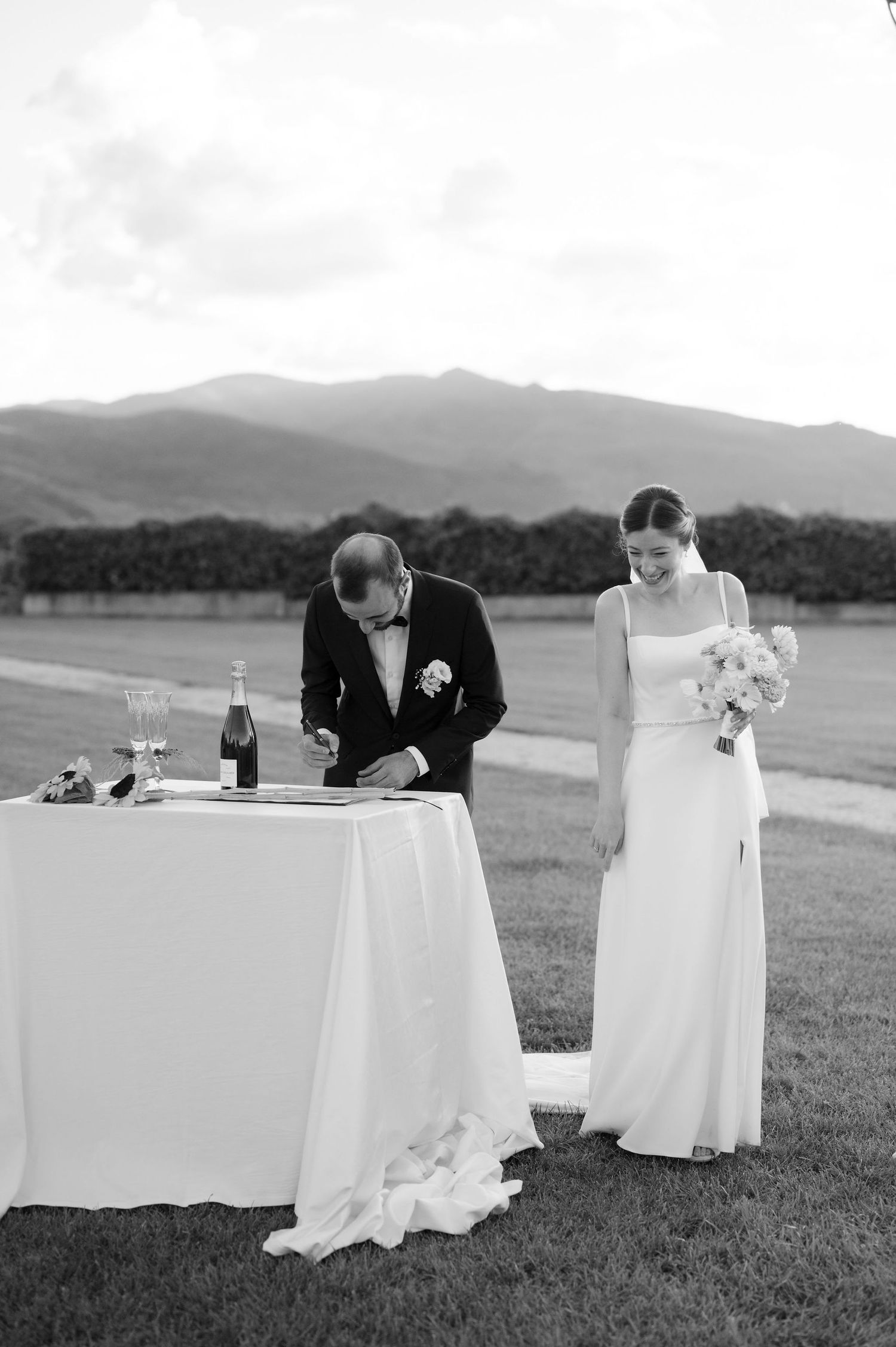 Black and white photo of wedding reception with mountain landscape and elegant table setting.