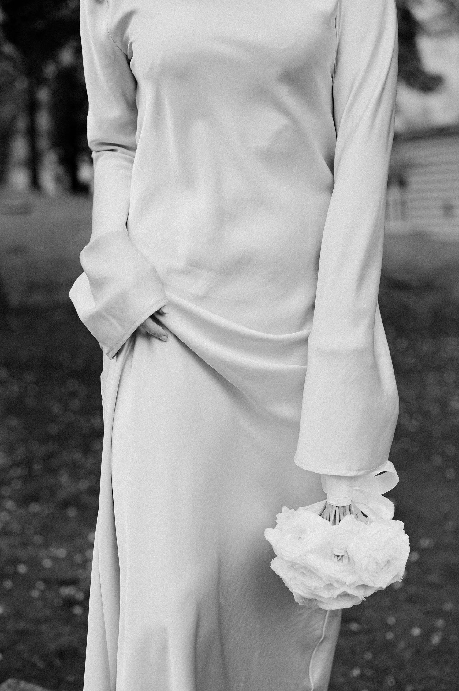 Elegant white bridal gown with delicate ruffle sleeve detail and flowing fabric.