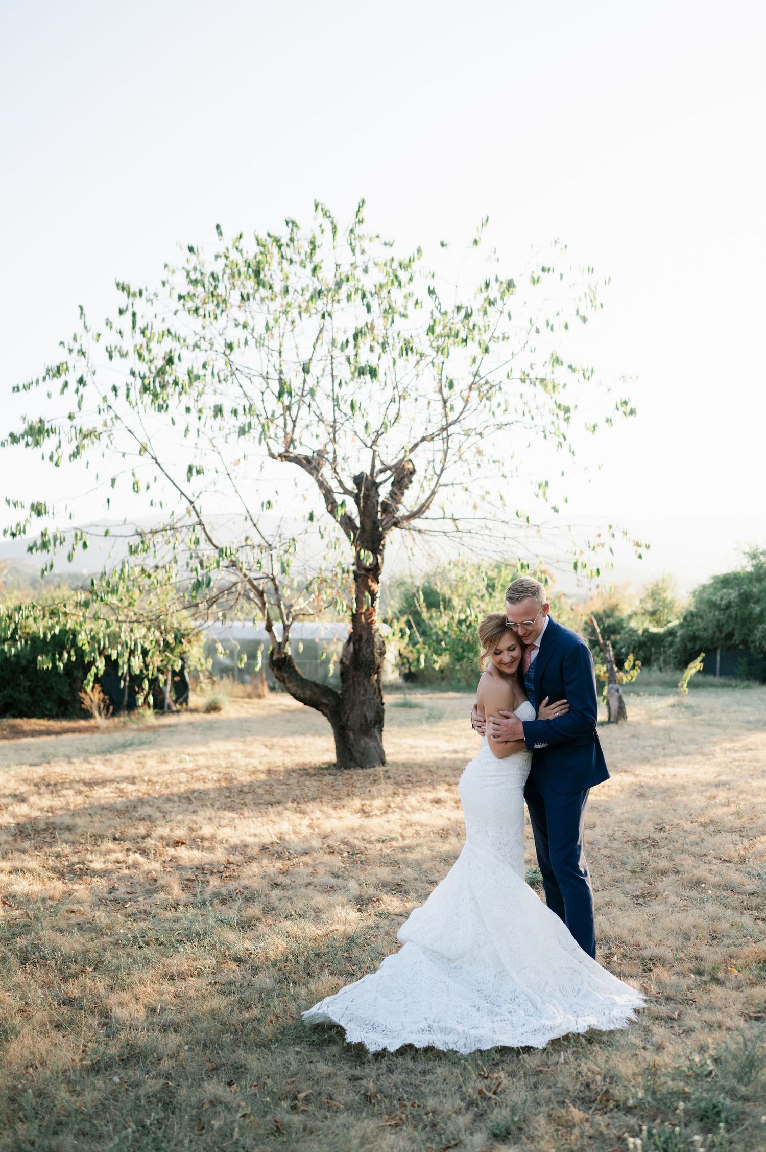 Romantic dance poses in rustic orchard setting.