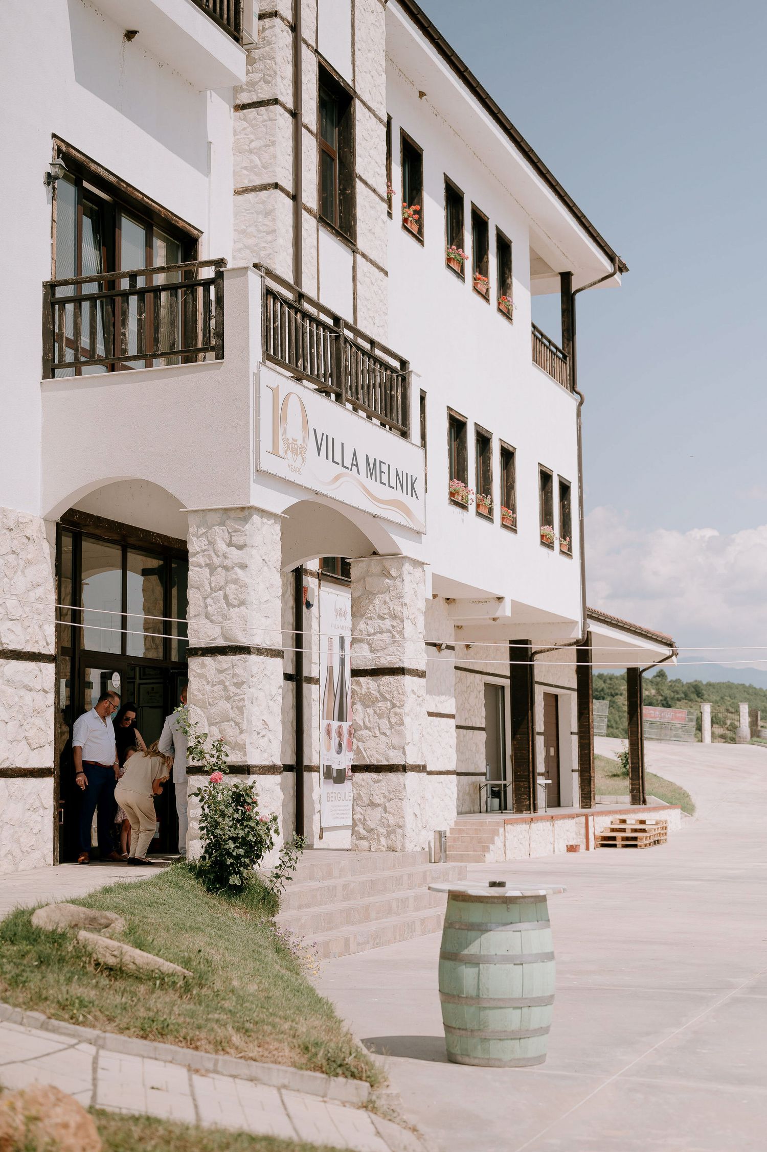 White stucco building with balconies and arched entryways at Villa Melnik.