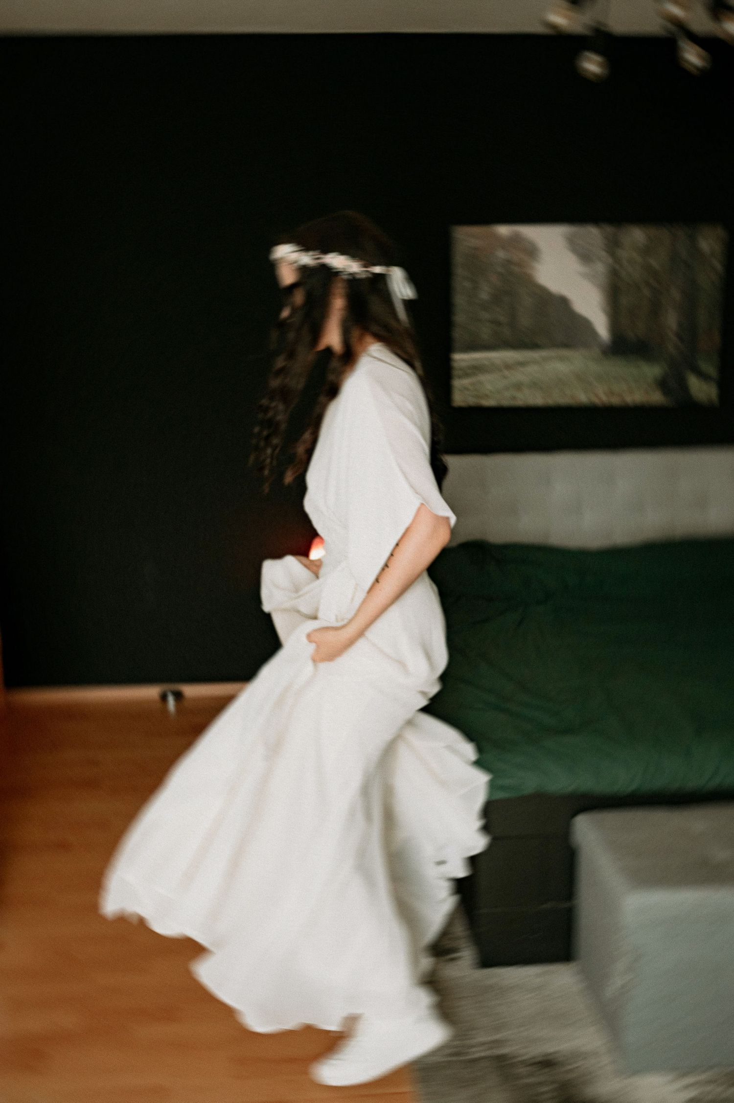 Motion blur photograph of spinning white dress in dimly lit room.