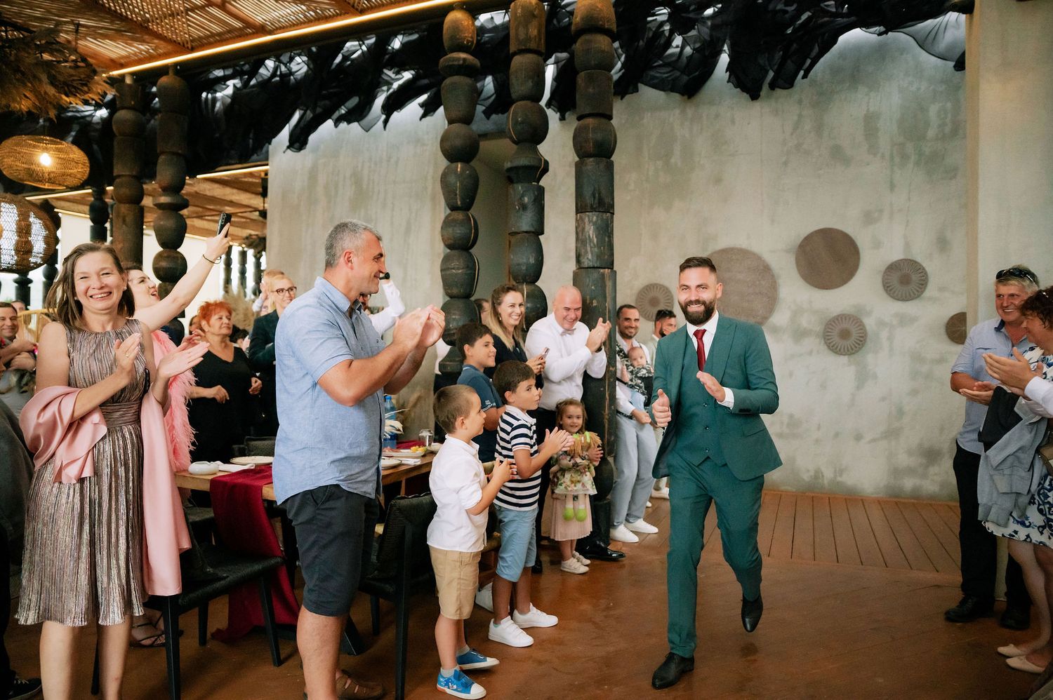 Wedding celebration with guests applauding in a rustic indoor venue.