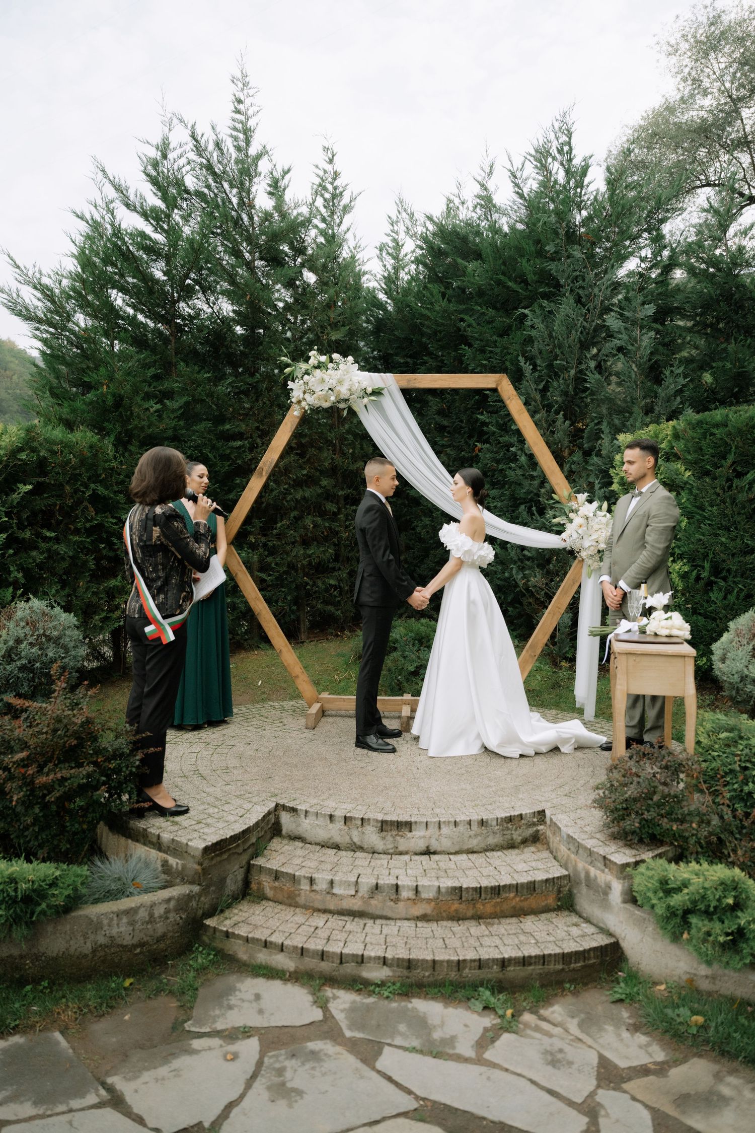 A series of wedding photos showing a couple's playful lightsaber duel on stone steps with an outdoor wooden arch backdrop.