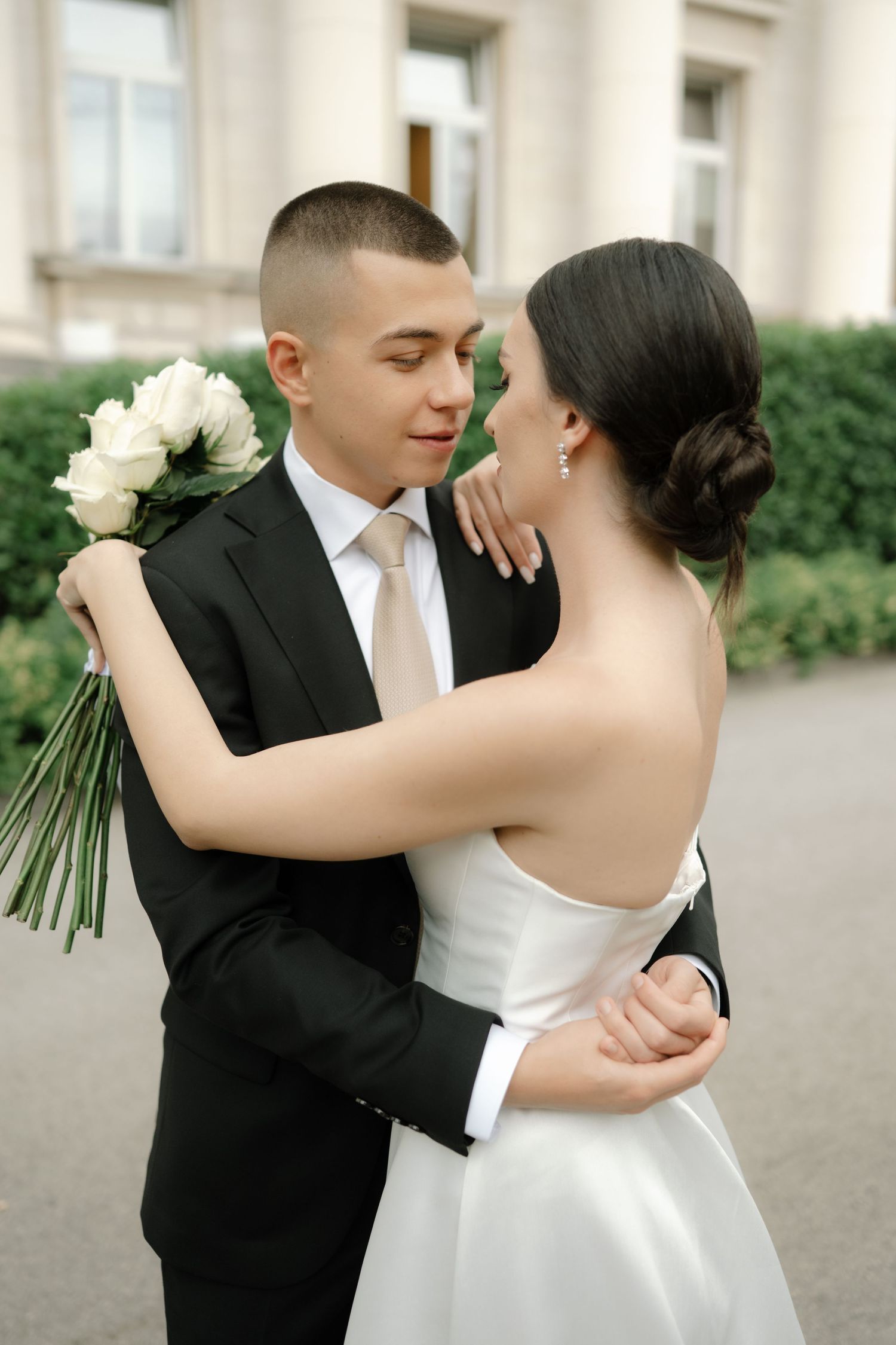 A romantic wedding sequence showing a couple dancing and embracing in formal attire against a backdrop of white columns.