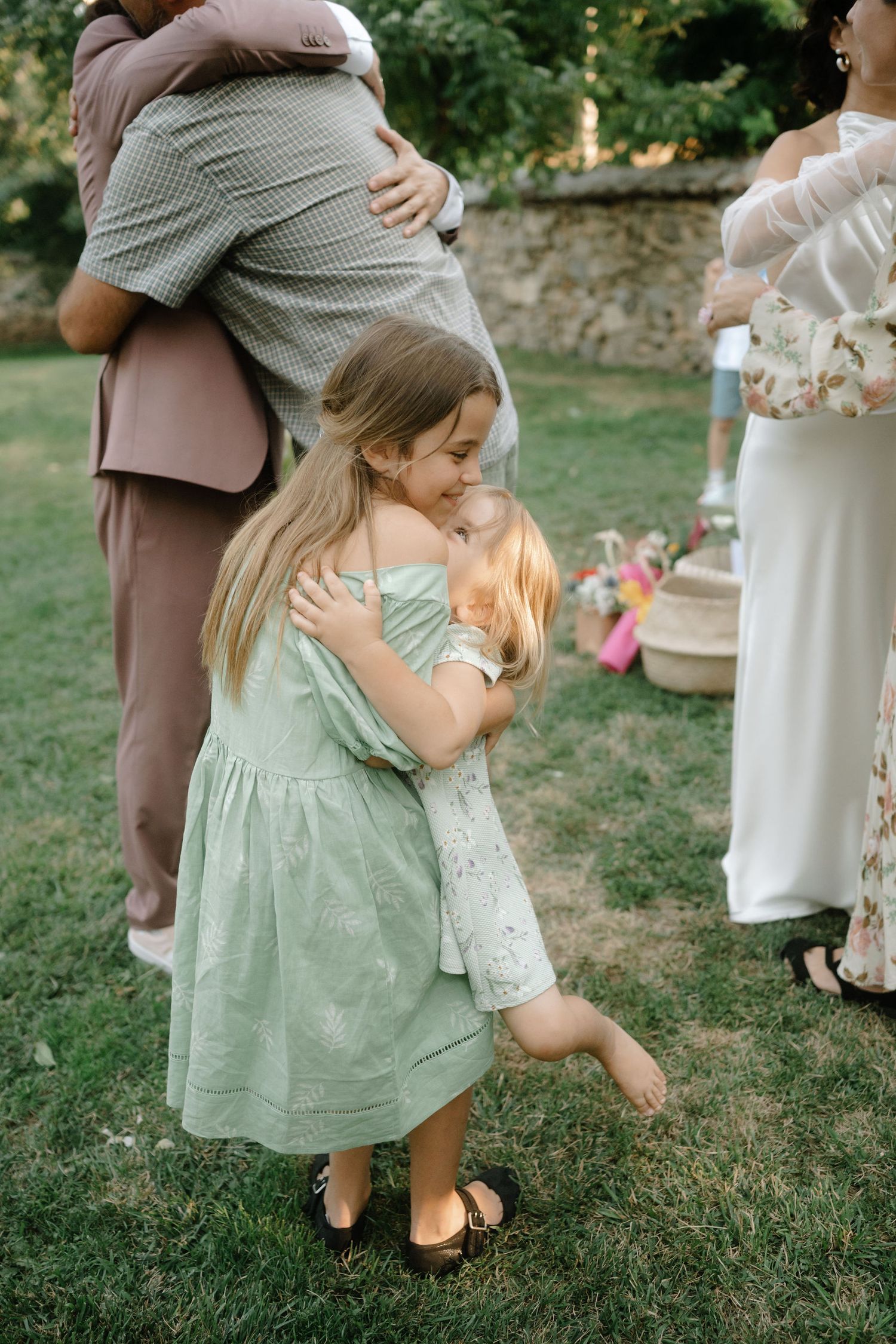 A series of candid moments showing a small child in a mint green dress playing outdoors at a garden event.