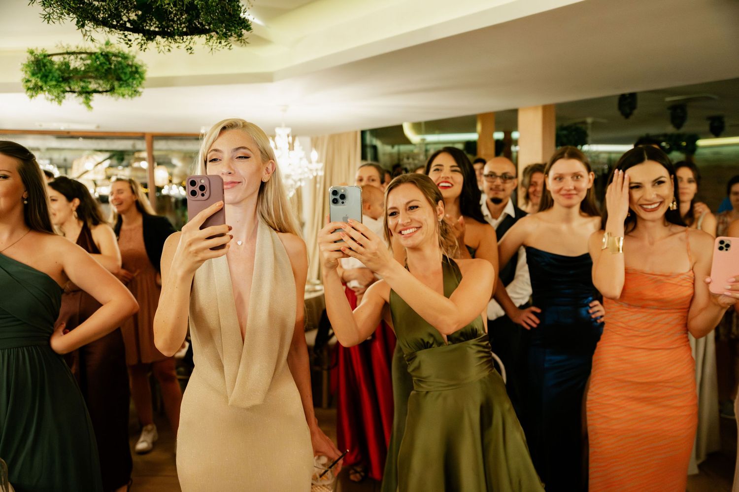 Wedding guests in formal attire dance and enjoy themselves at an evening celebration.