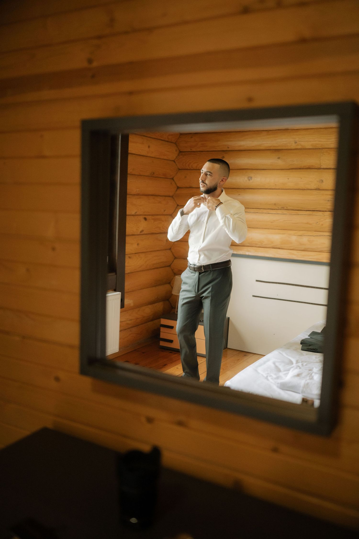 A sequence of mirror reflections shows someone in a white shirt and dark pants moving against wooden paneled walls.