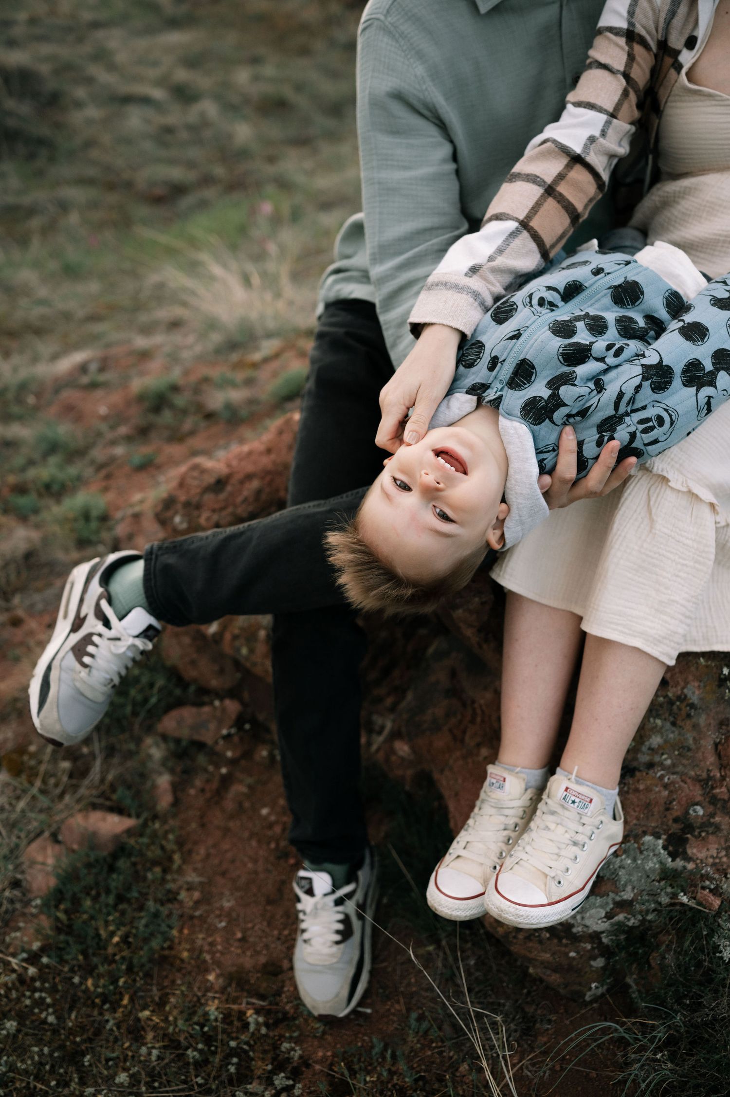 A series of five images showing legs and shoes resting on a dark rocky surface, creating a romantic artistic composition.