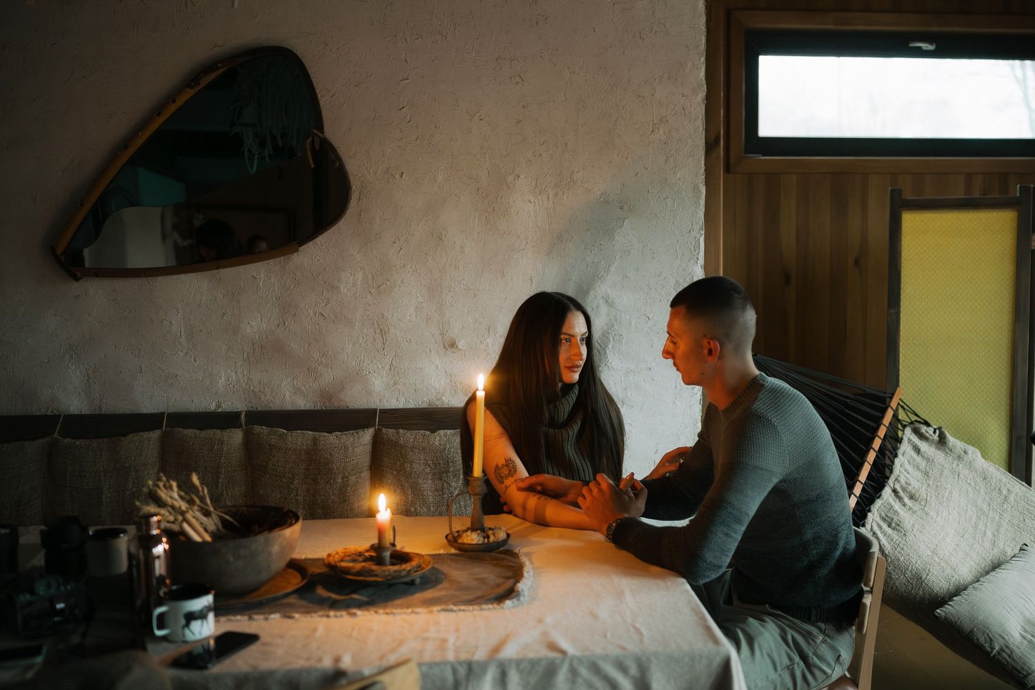 Romantic candlelit evening with couple enjoying intimate conversation at home.