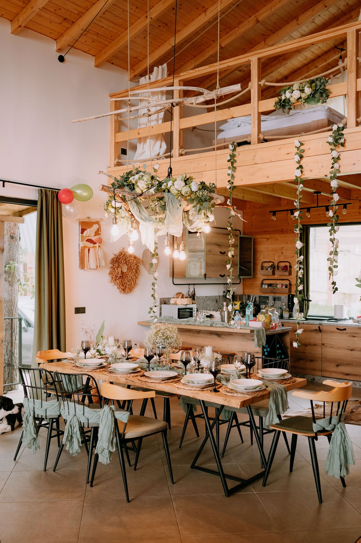 Rustic wedding venue with wooden ceiling, hanging lights and elegant table settings.
