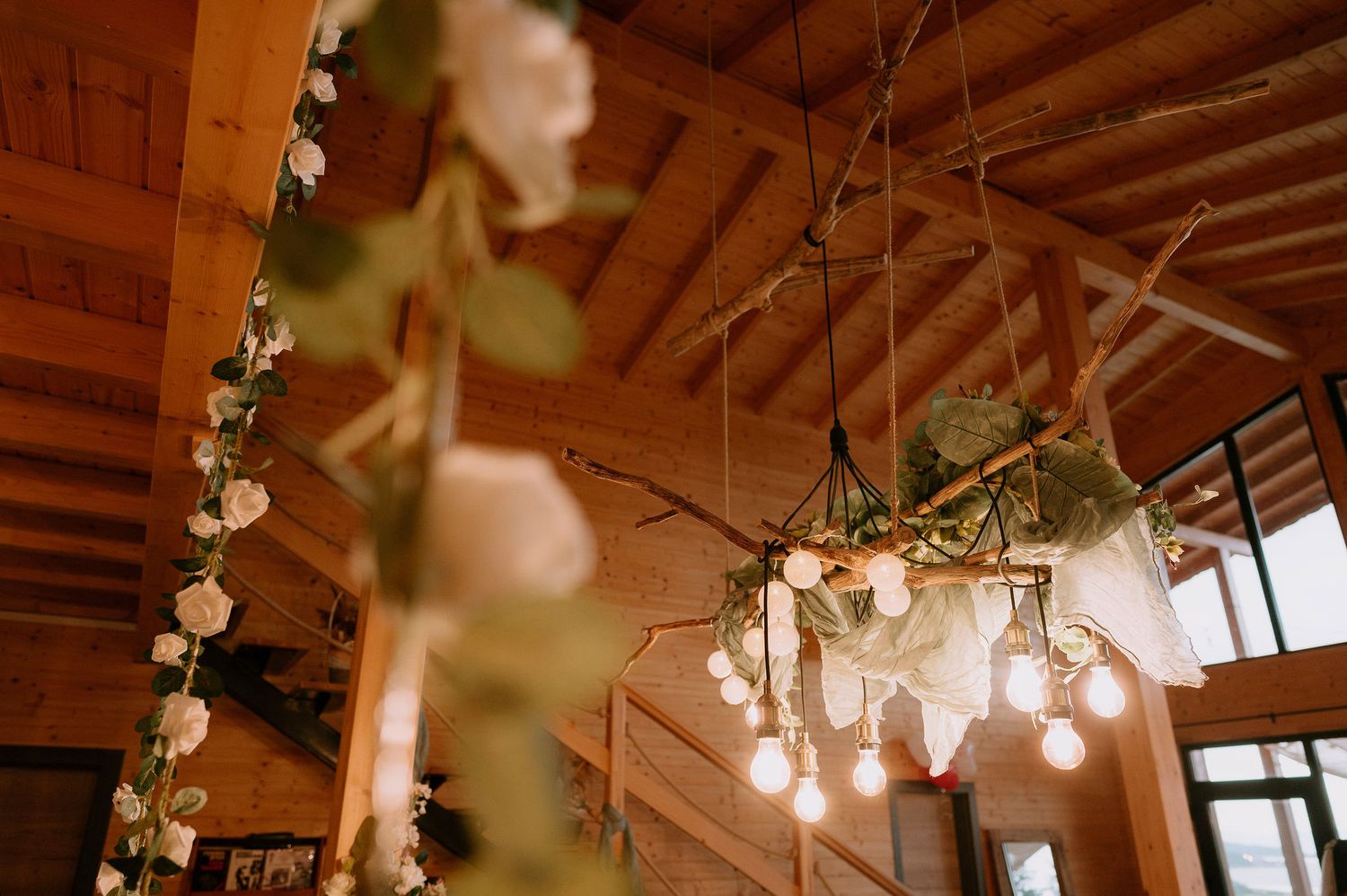 String lights and greenery hang from wooden beams creating a romantic atmosphere.