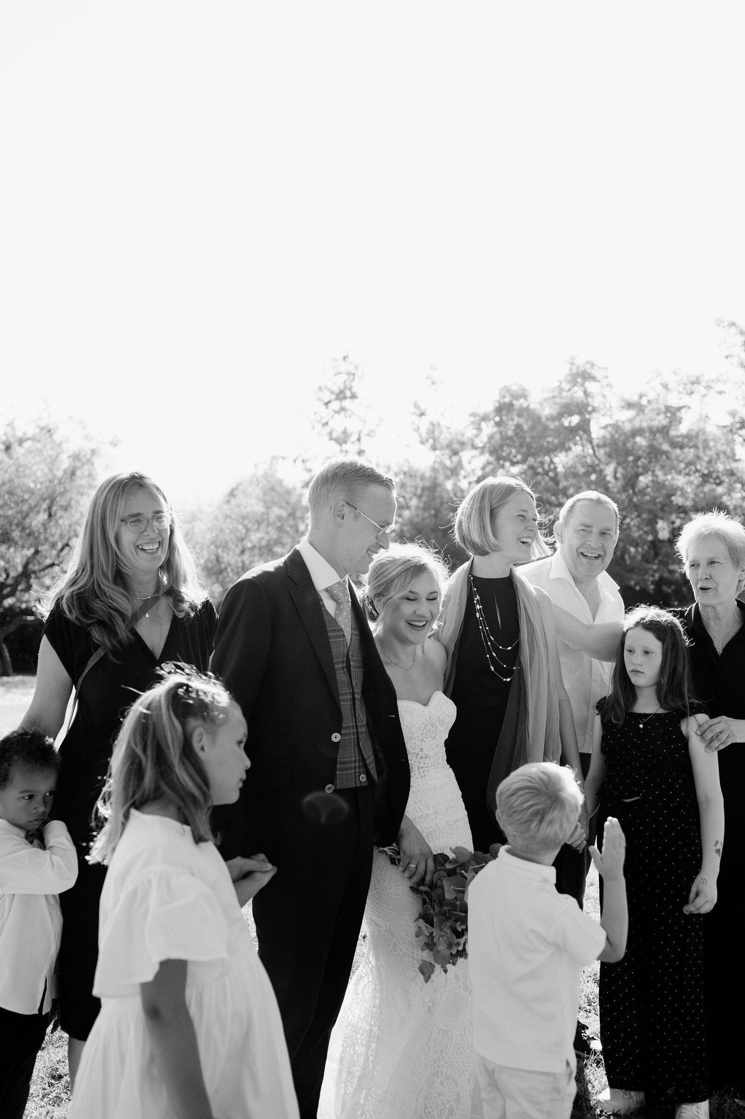 Black and white photo series capturing candid wedding celebration moments outdoors.