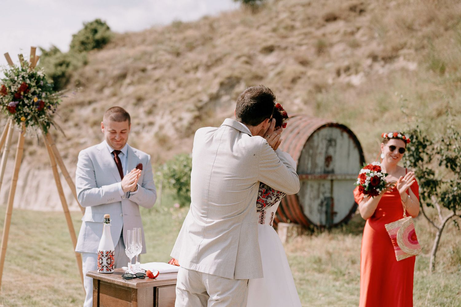 Wedding ceremony setup in a desert landscape with wooden furniture and floral decorations.