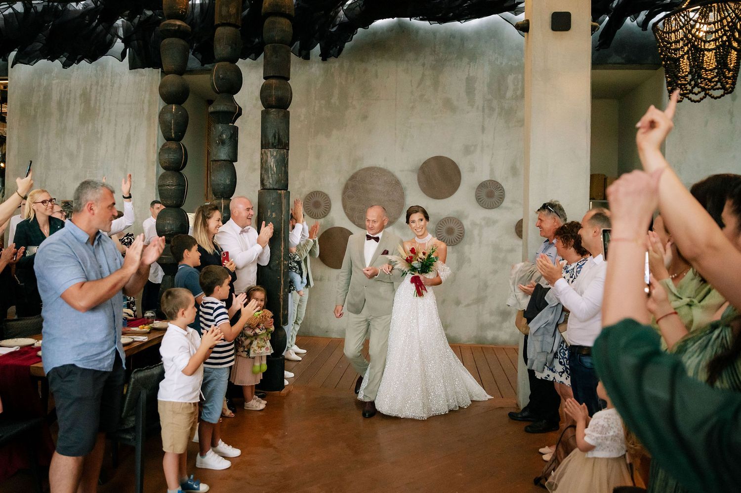 Wedding ceremony exit with guests lining the aisle and applauding.