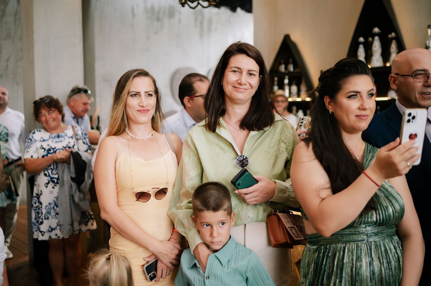 Wedding guests in pastel and jewel-toned attire gather during the celebration.