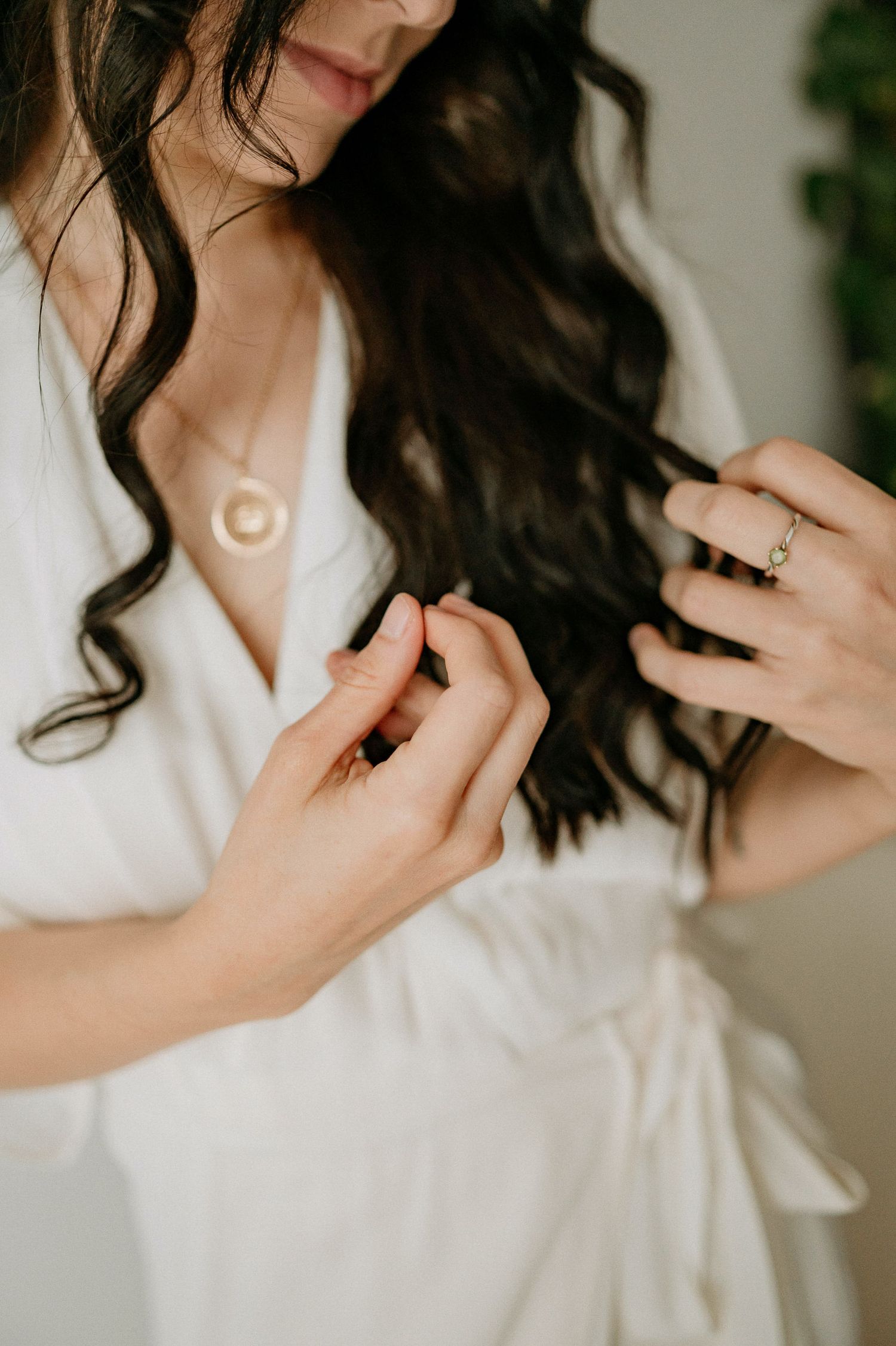 Close-up shot of long dark hair and white clothing in soft natural lighting.