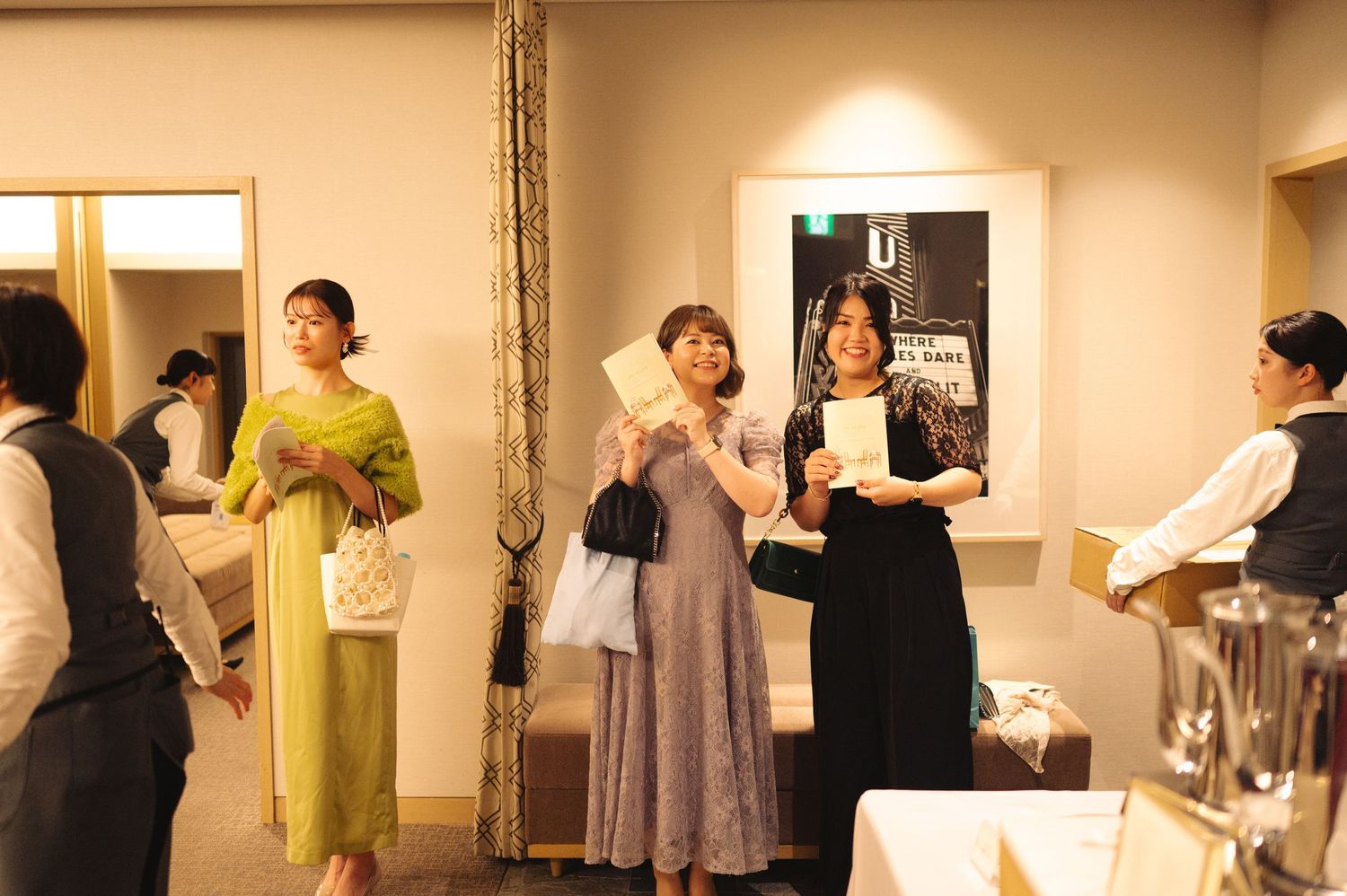 Group of people gathered in an indoor venue with warm lighting.