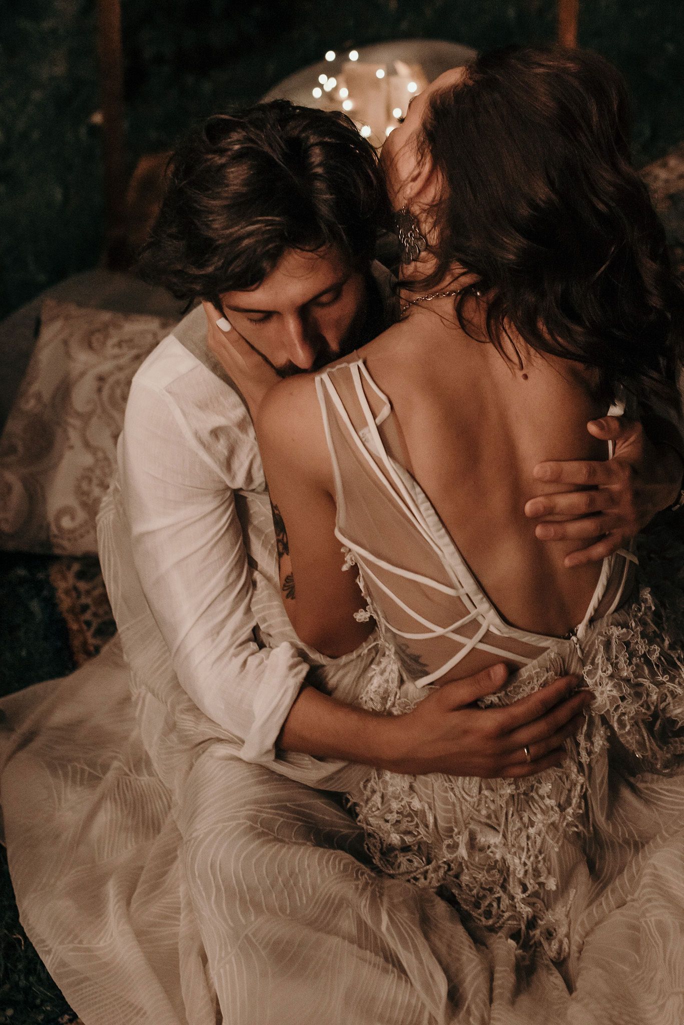 Romantic couple in white wedding attire share intimate moments in a series of moody, artistic photographs.