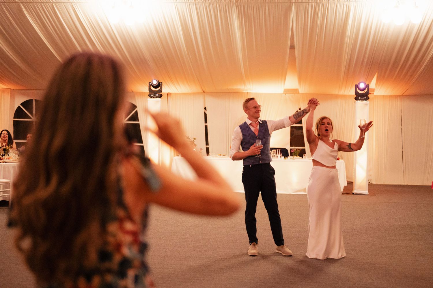 A sequence of dance moves captured in a wedding reception venue with warm lighting and white decor.