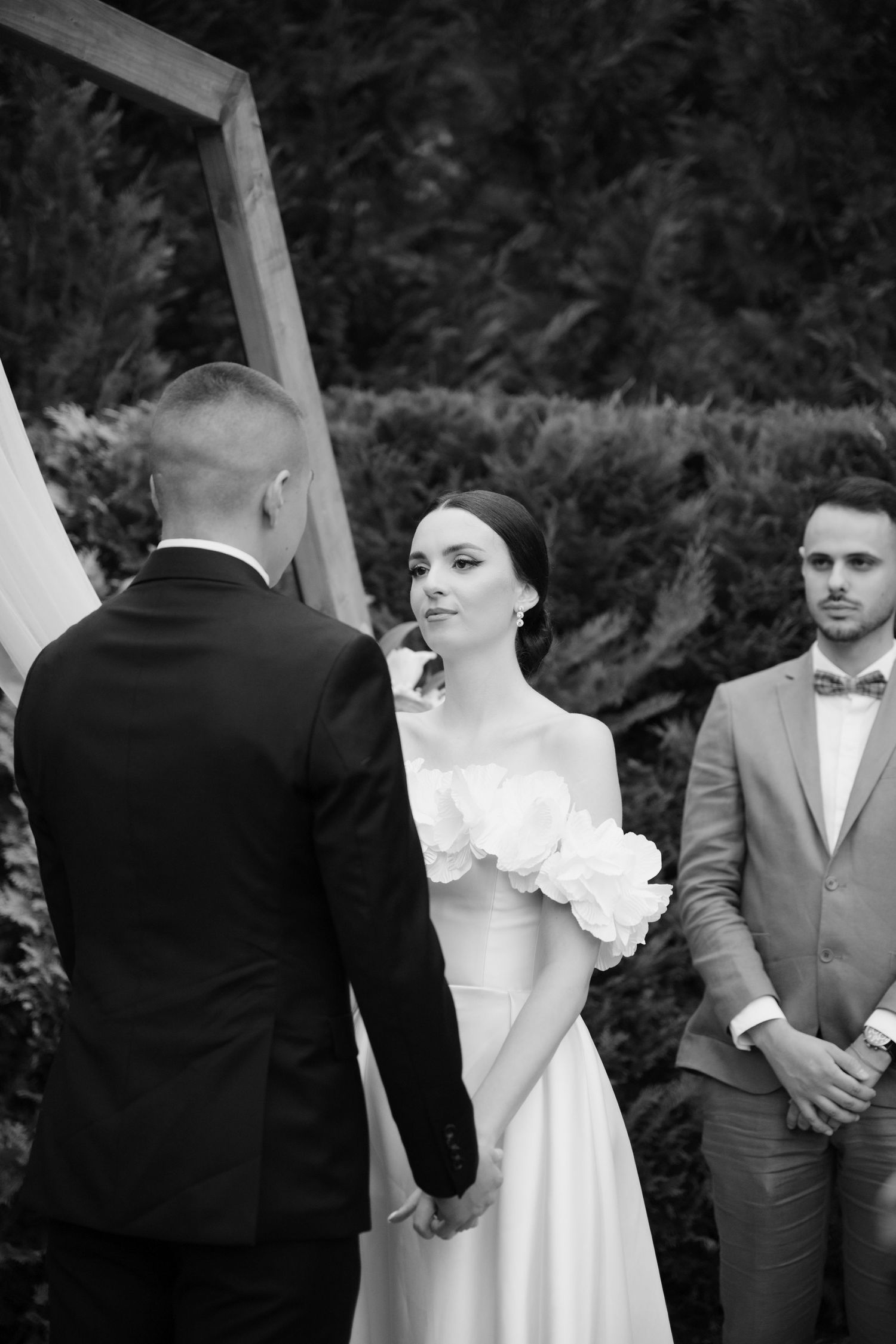 A black and white wedding sequence showing a couple exchanging vows in an outdoor garden setting.