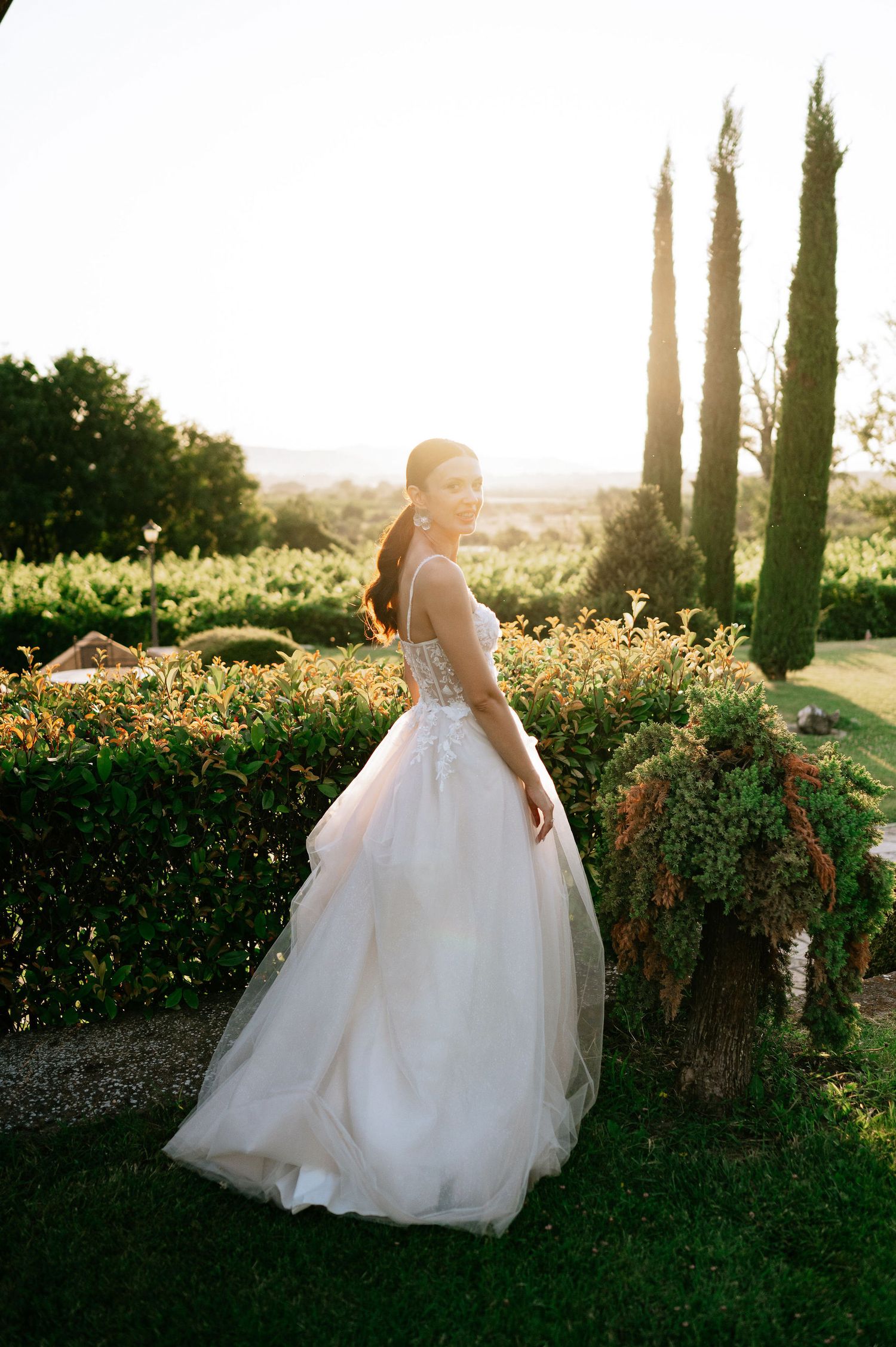 Ethereal wedding photography featuring a flowing white gown in a garden with golden hour lighting.