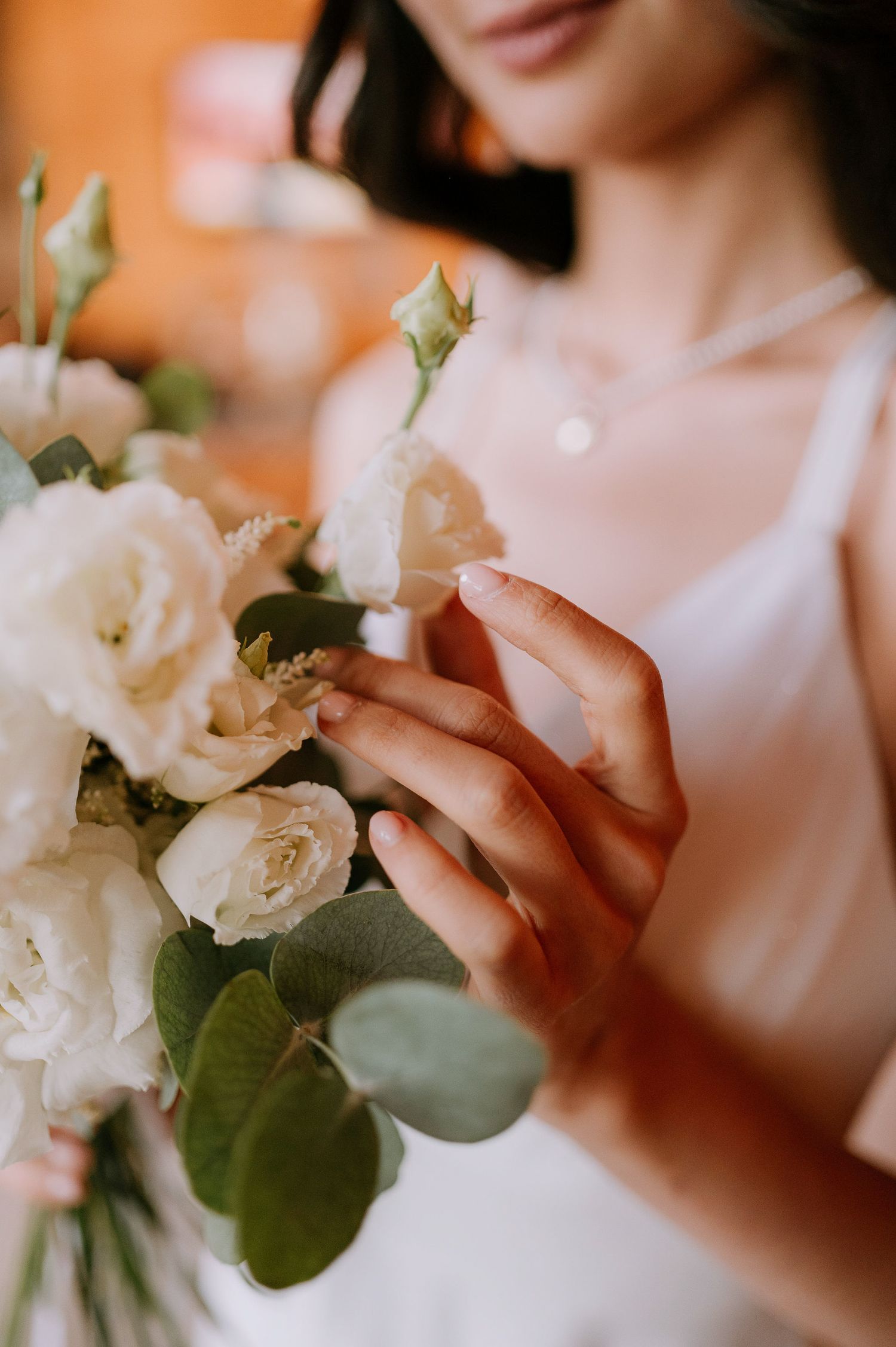 Close-up of white roses and eucalyptus in wedding bouquet.