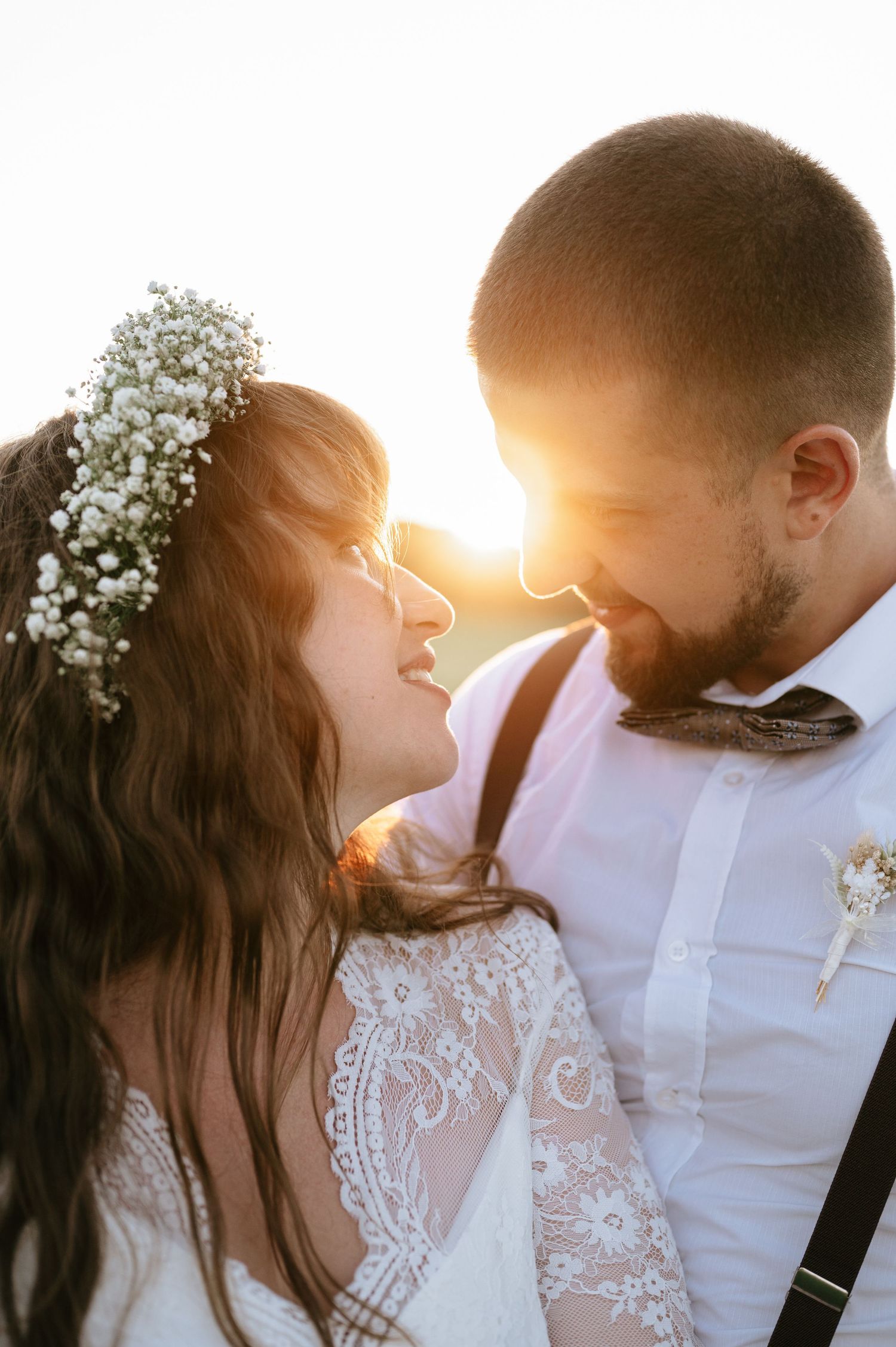 Romantic sunset wedding portraits with couple in white attire and baby's breath crown.