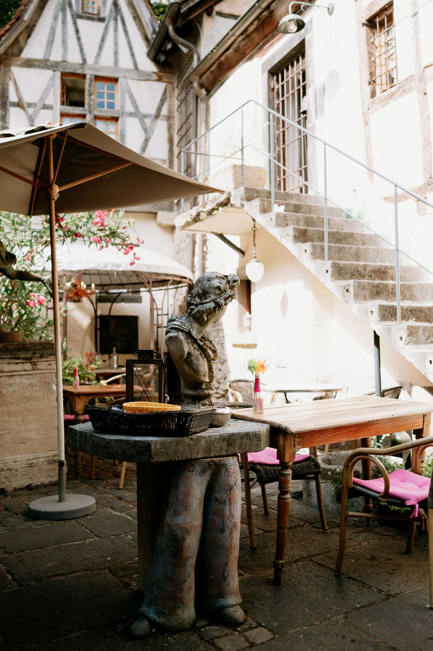 Outdoor seating area with rustic furniture and stone walls in a garden setting.