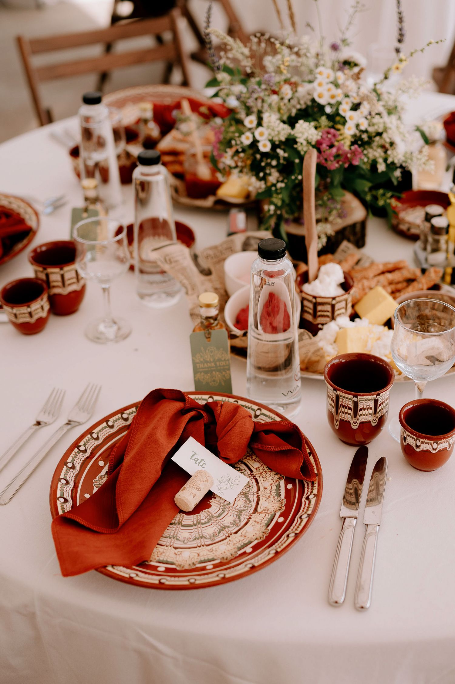 Elegant table settings with red accents, floral centerpieces and fine dinnerware.