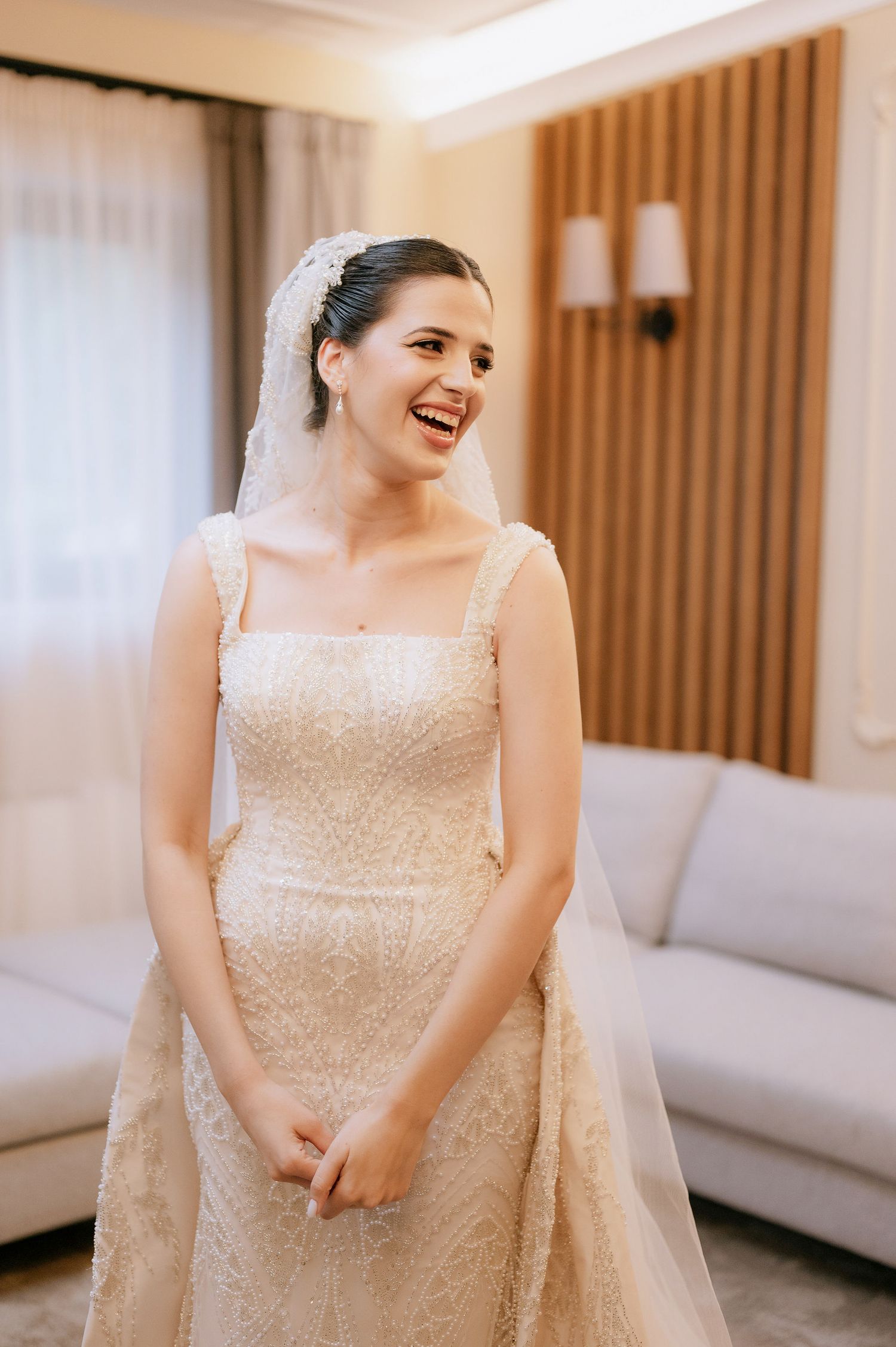 Bride in a sequined wedding gown shares joyful moments during pre-ceremony preparations.