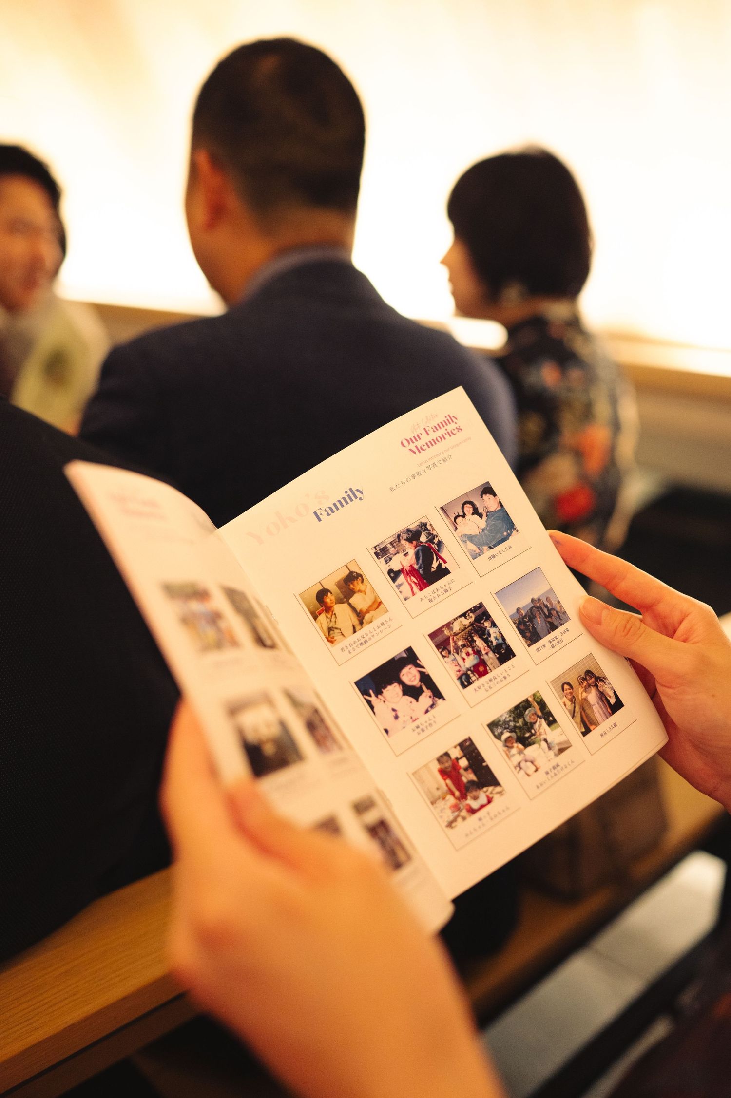 Hand holding open photo album or memory book during formal gathering.