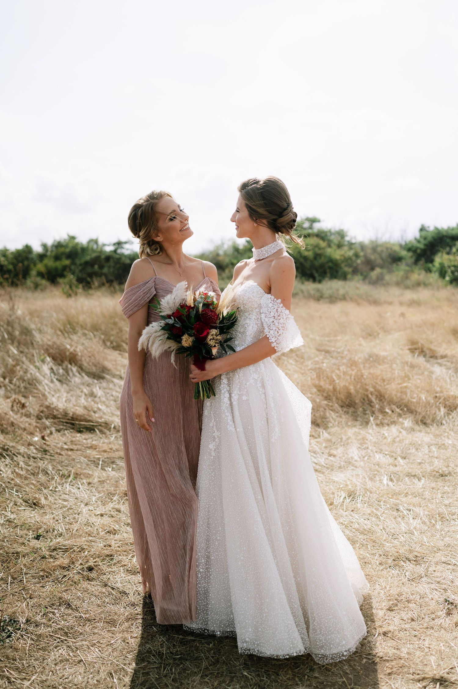 Two people in formal wear share a tender moment against a natural backdrop.