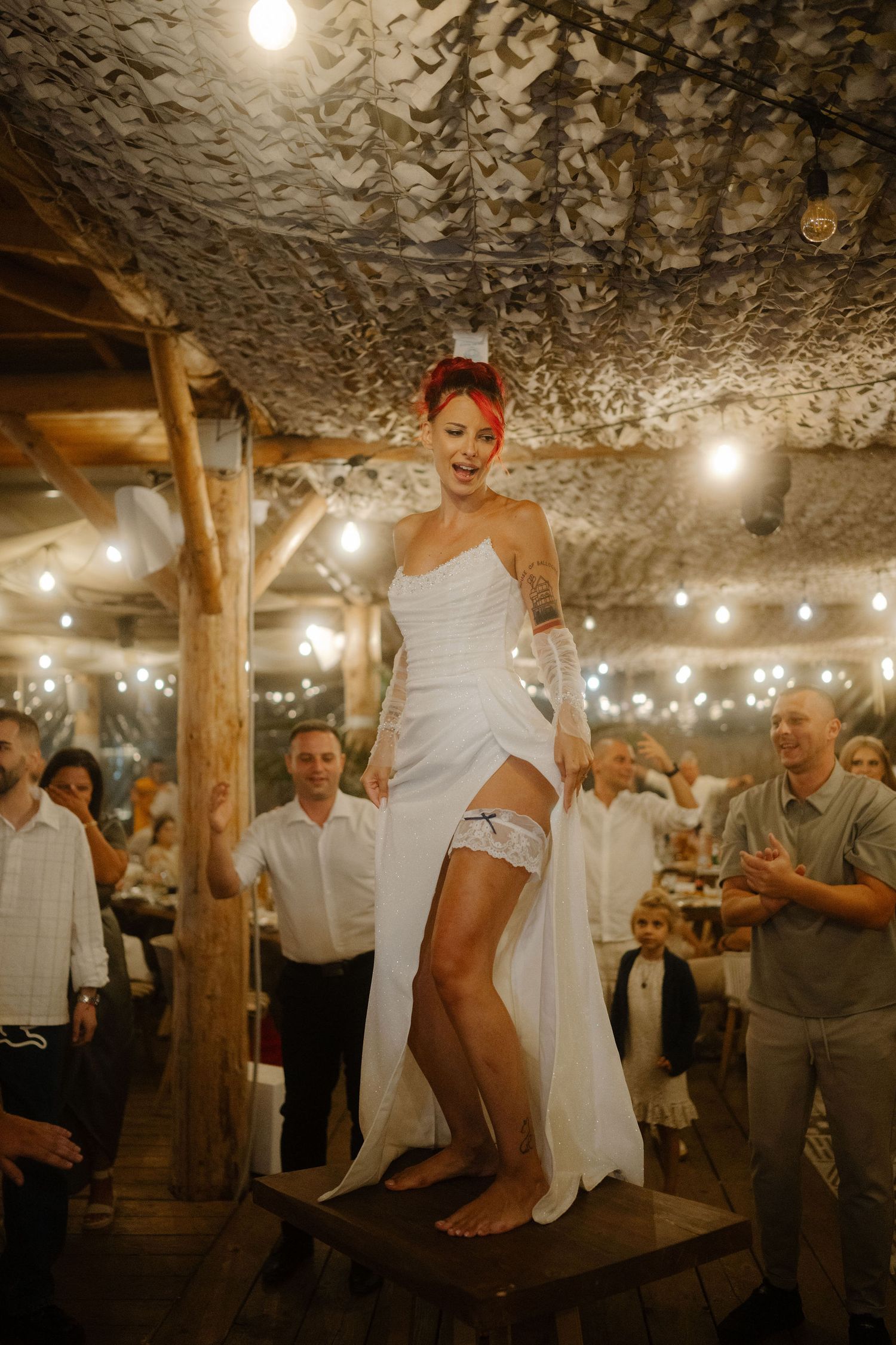 A sequence of candid wedding celebration moments in a rustic stone cellar with string lights creating warm ambiance.