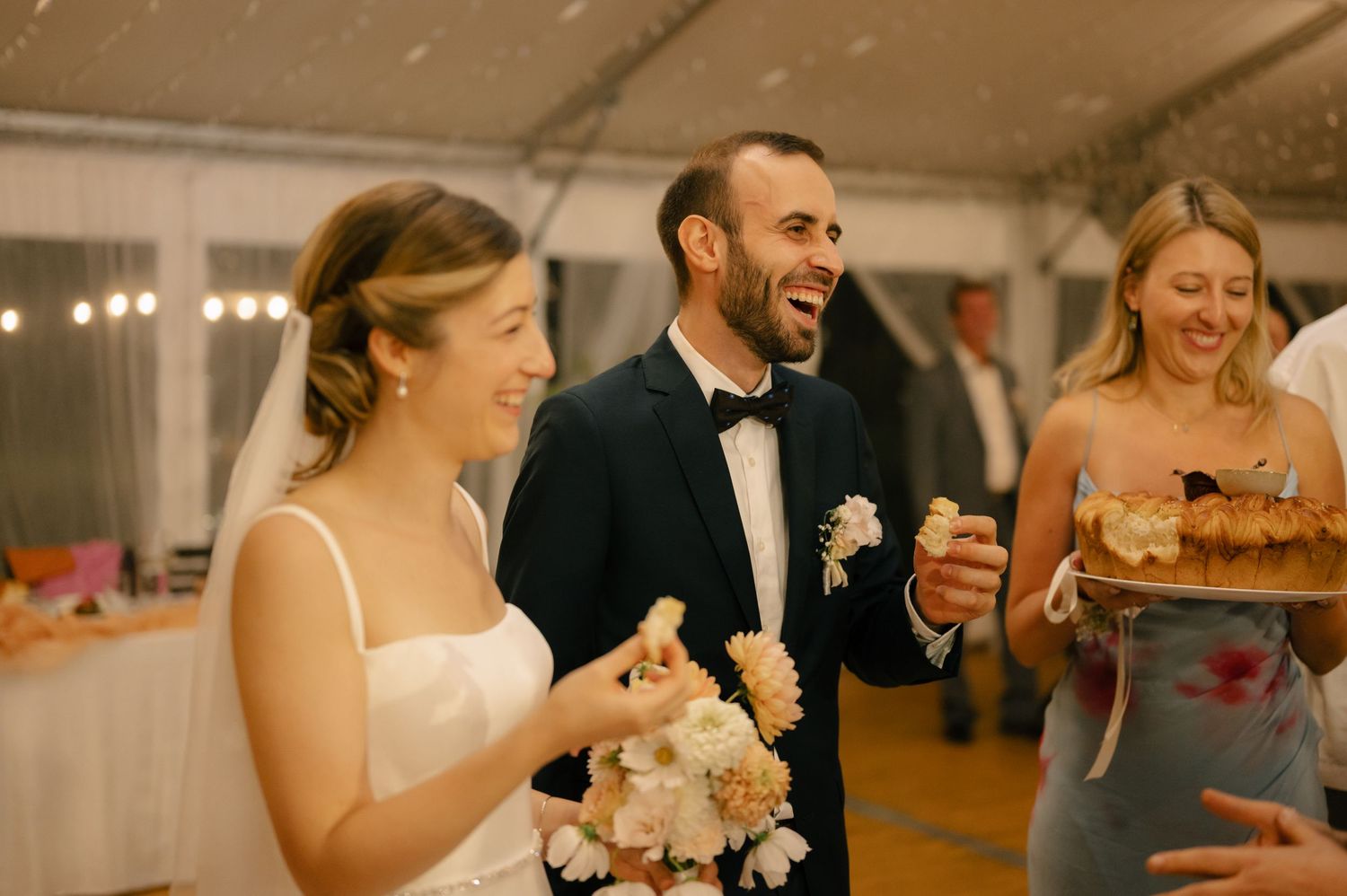 A bride and groom share a joyful moment of laughter during their wedding reception.