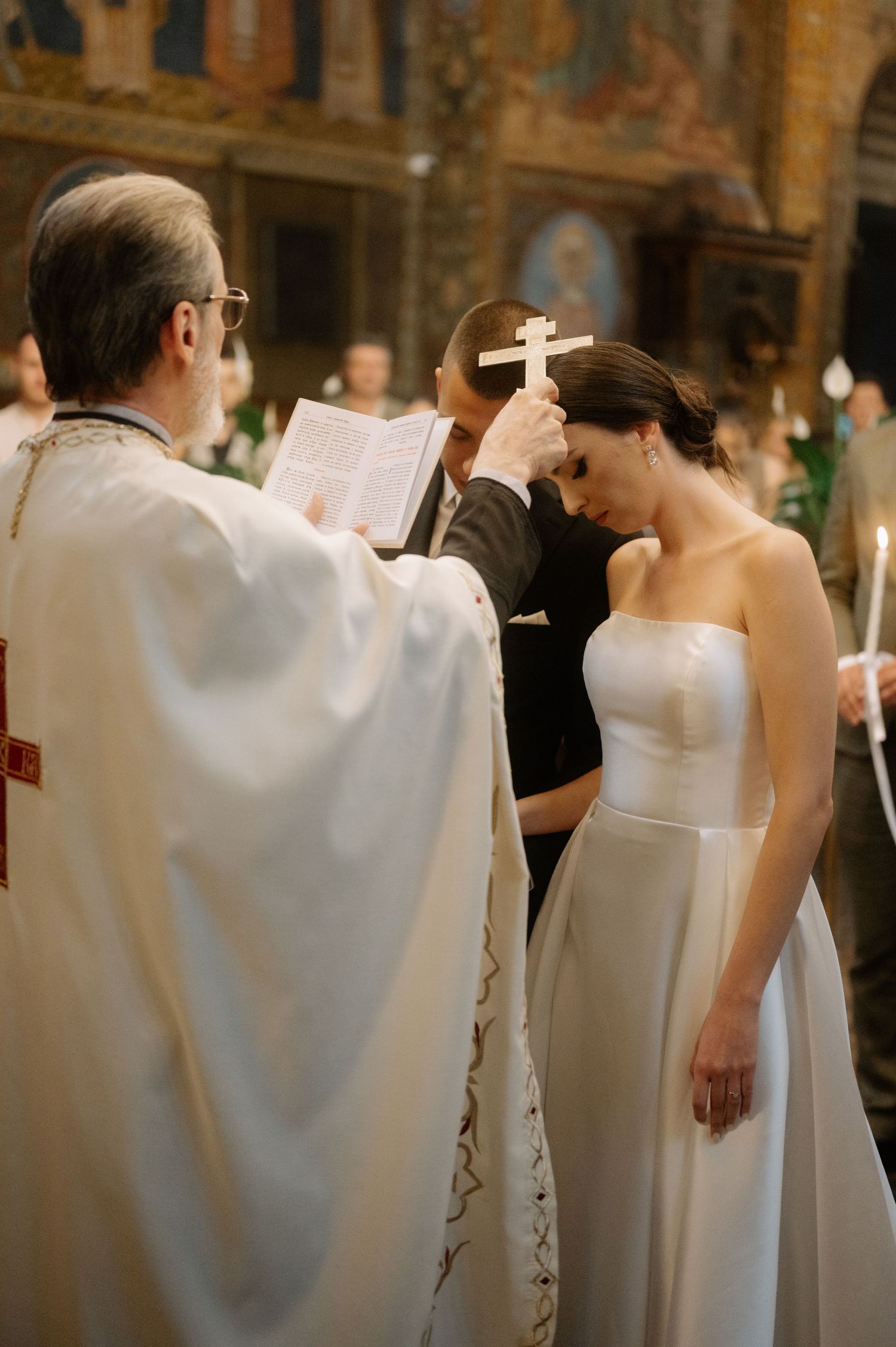 A line of people in white robes stand during a formal church ceremony or religious service.