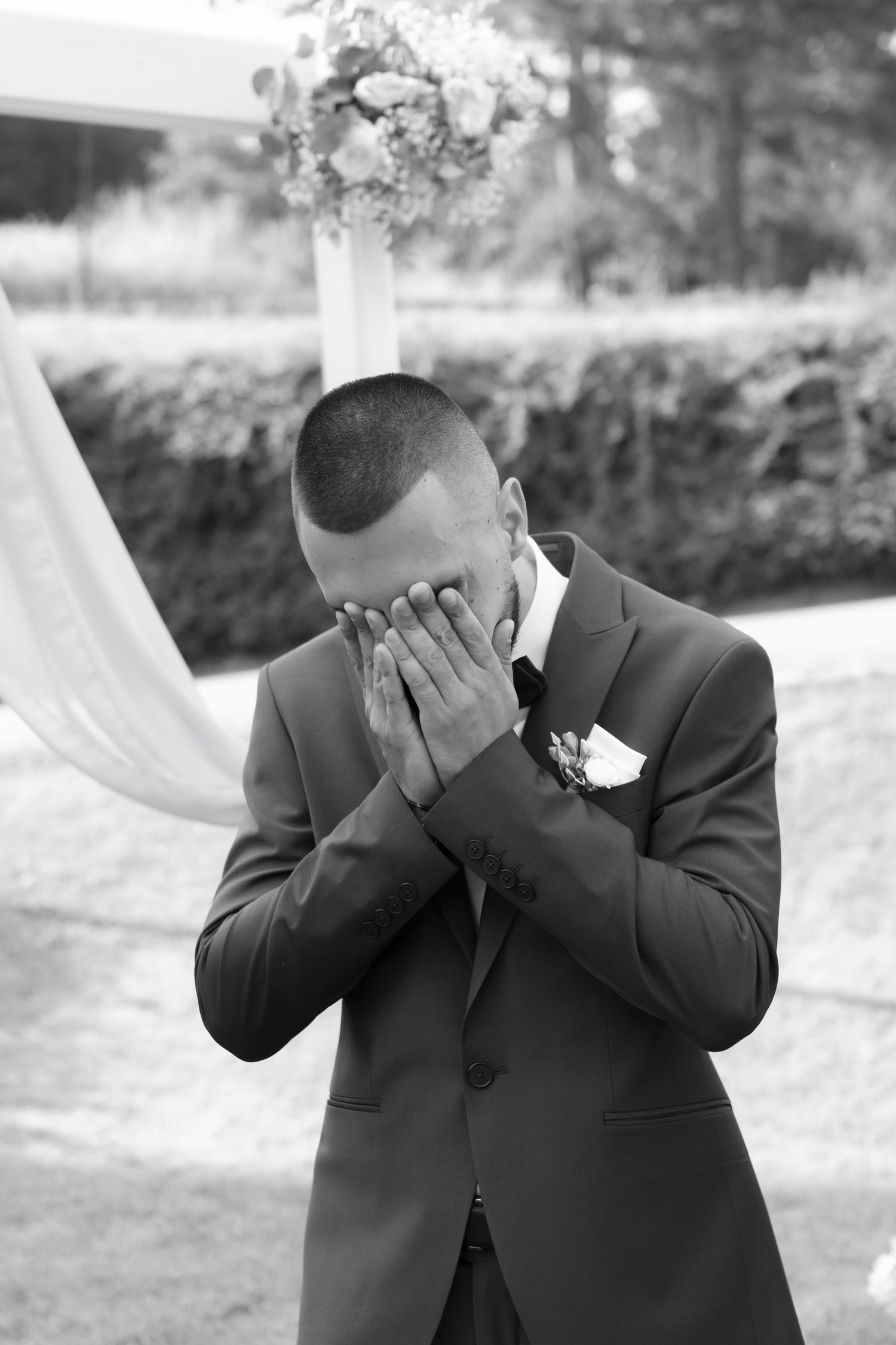 Black and white photo sequence showing a person in a suit covering their face with their hands in progressive shots.