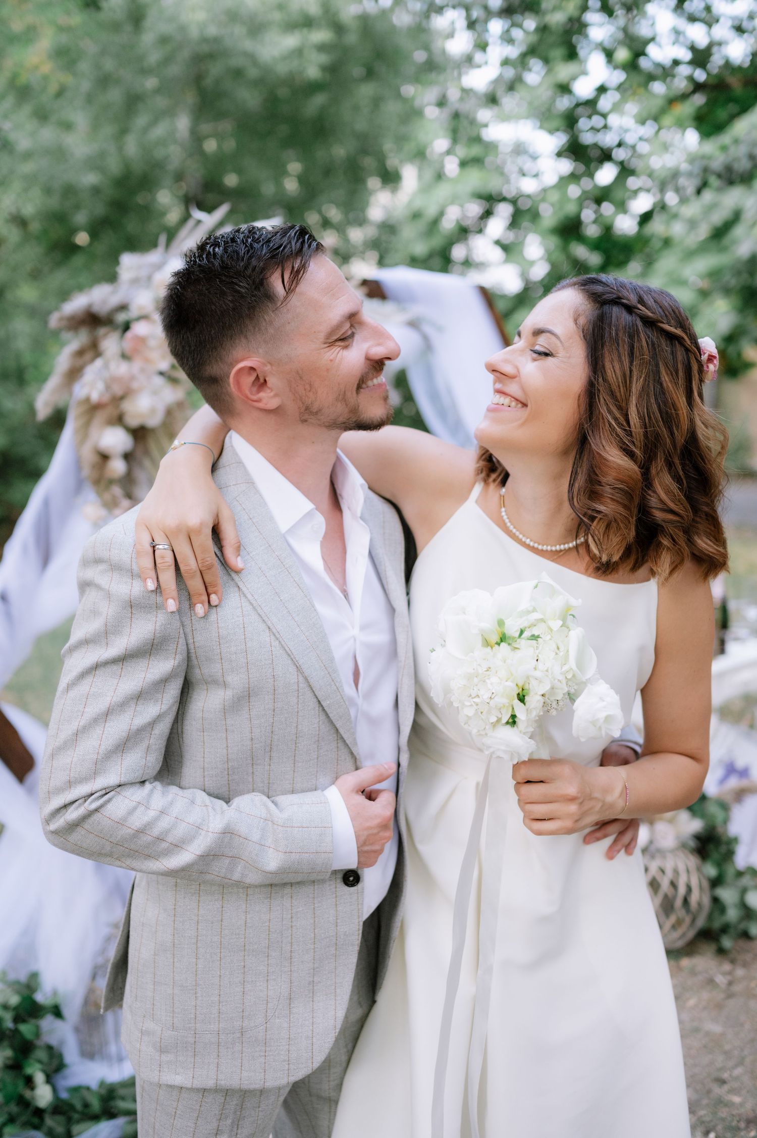 A romantic wedding photo sequence showing a couple in white and beige sharing joyful moments in a garden setting.