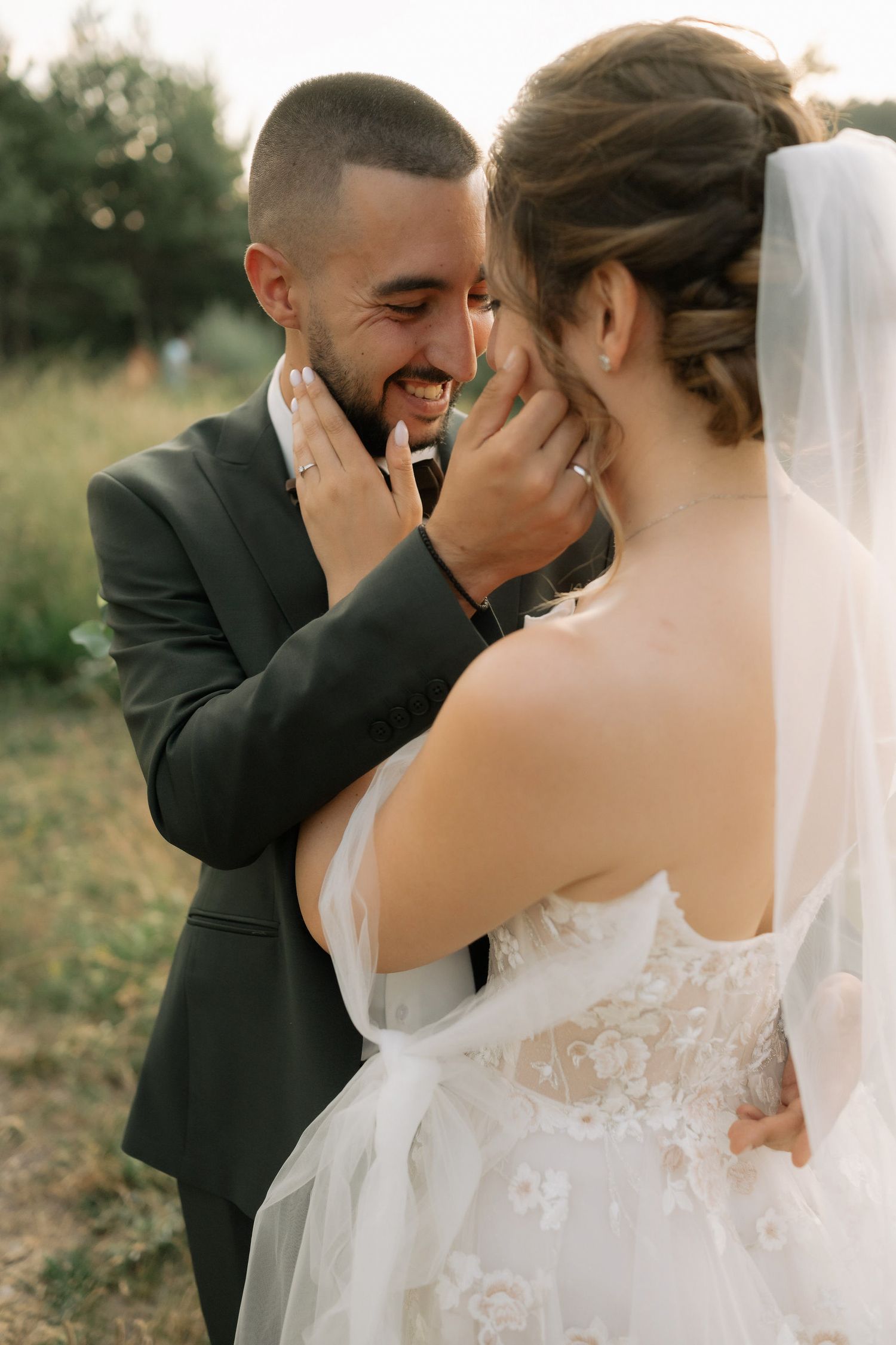 Emotional first look moment between newlyweds in outdoor wedding setting with natural lighting and joyful expressions.