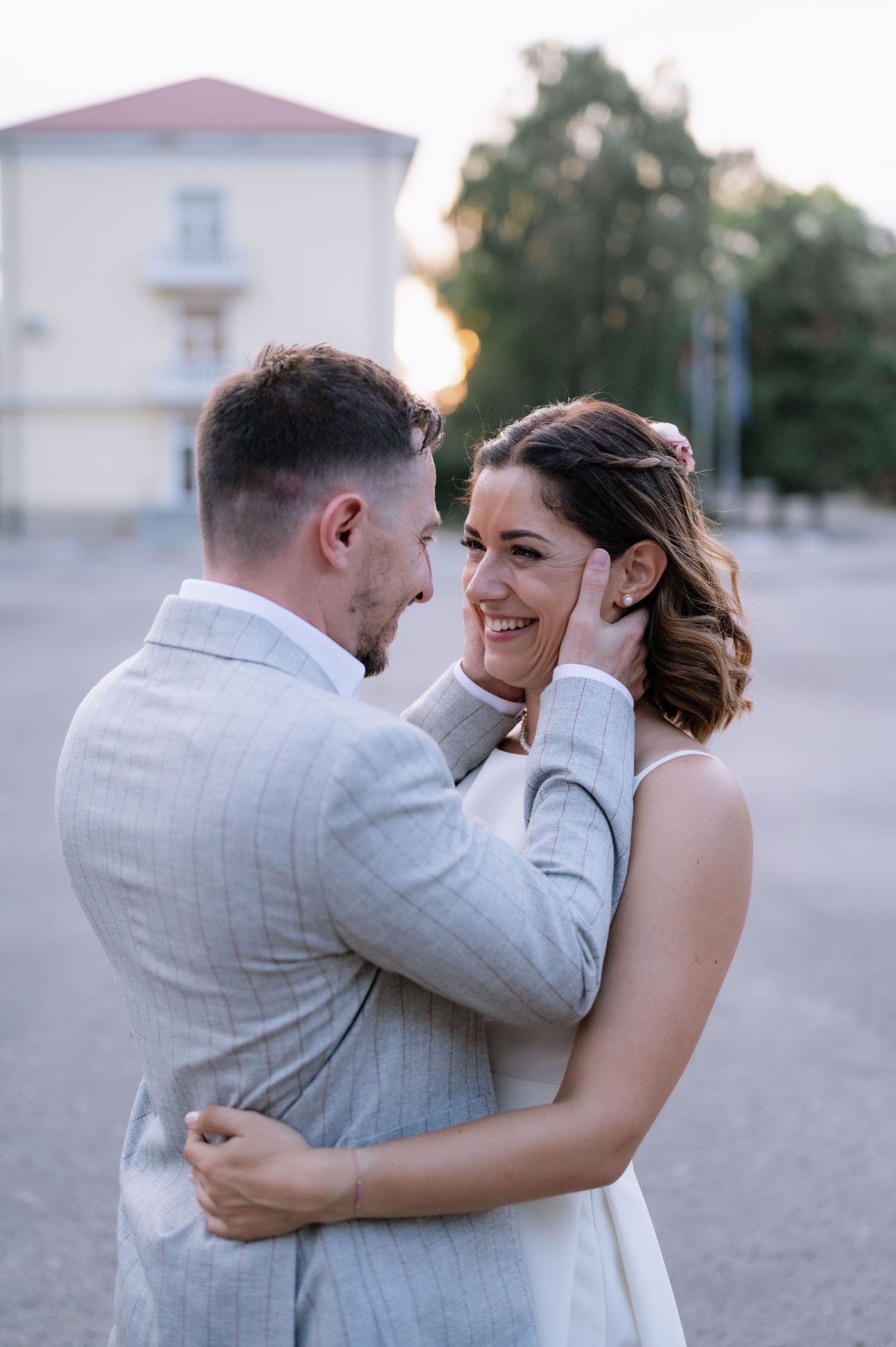 A romantic moment between newlyweds sharing an intimate embrace outdoors during golden hour.