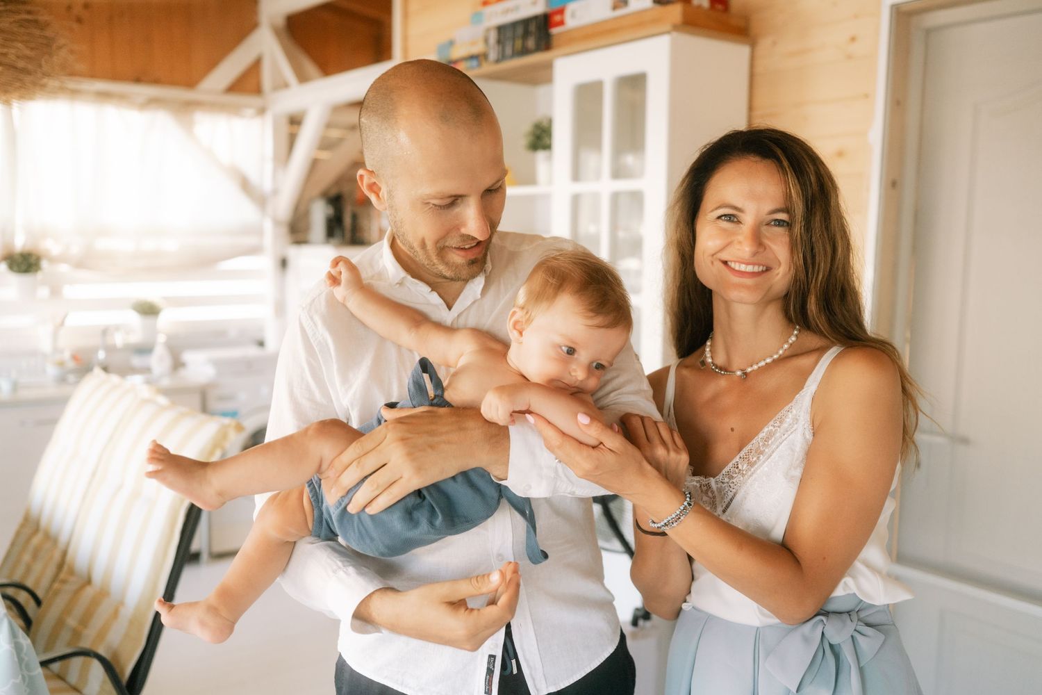 A collage of tender family moments showing parents bonding with their baby in a bright, modern home setting.