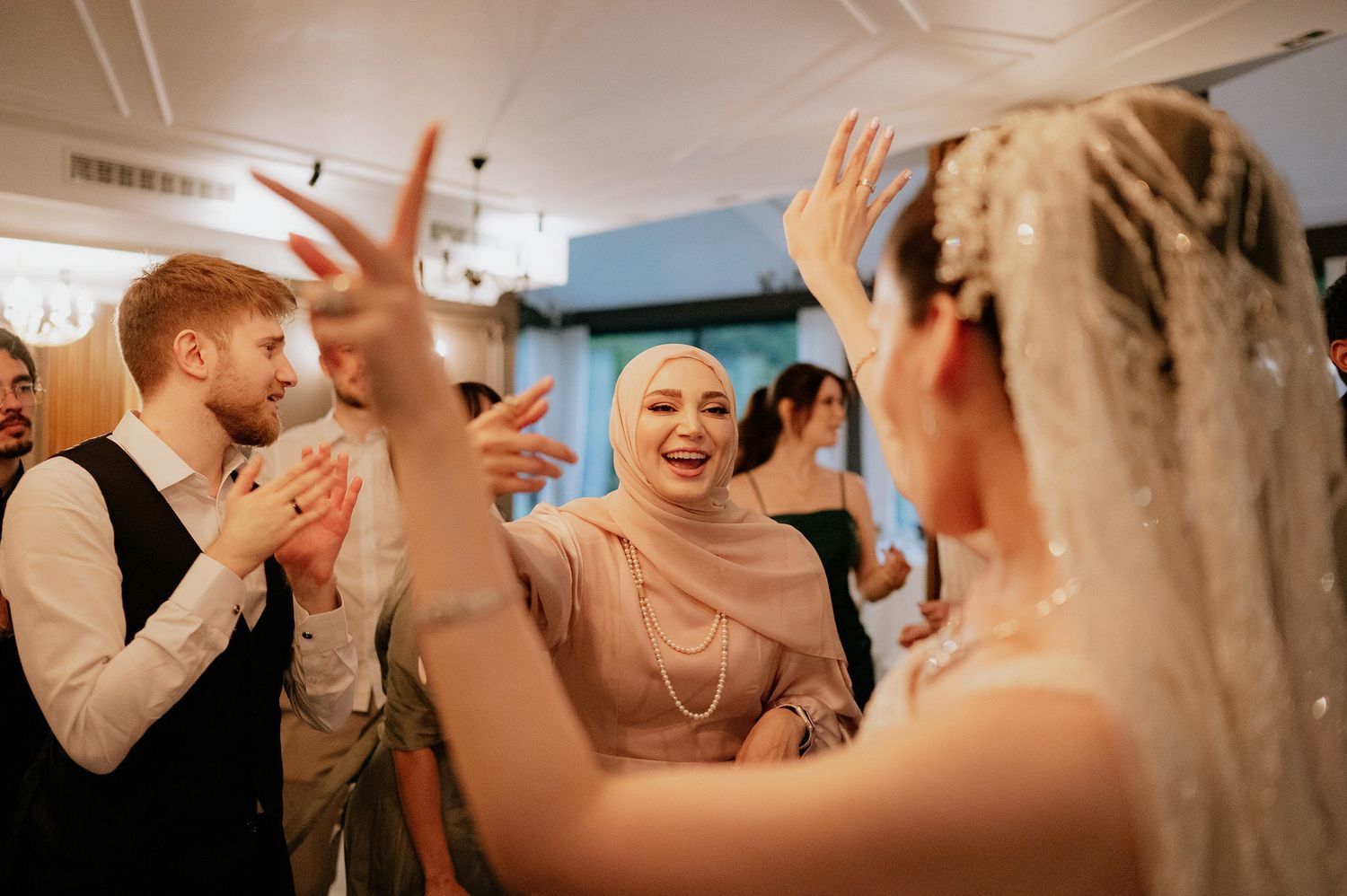 Candid moments of wedding guests celebrating and dancing at an indoor reception.