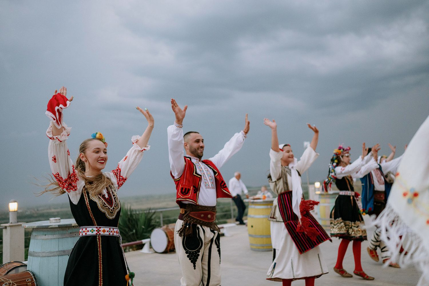 Guests raise their arms in celebration during an outdoor wedding reception.