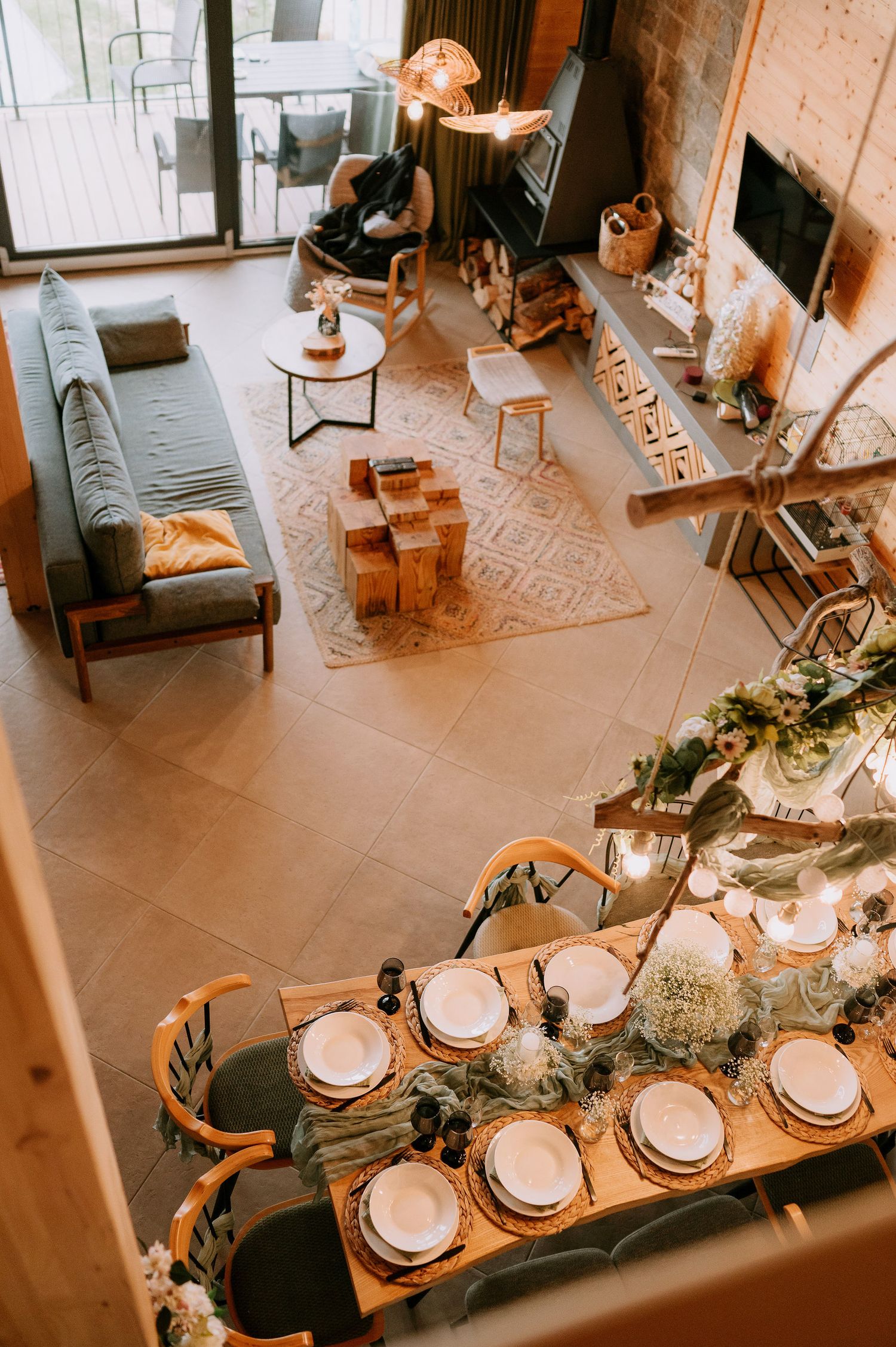 Elegant wedding reception table setup with white place settings and rustic decor viewed from above.