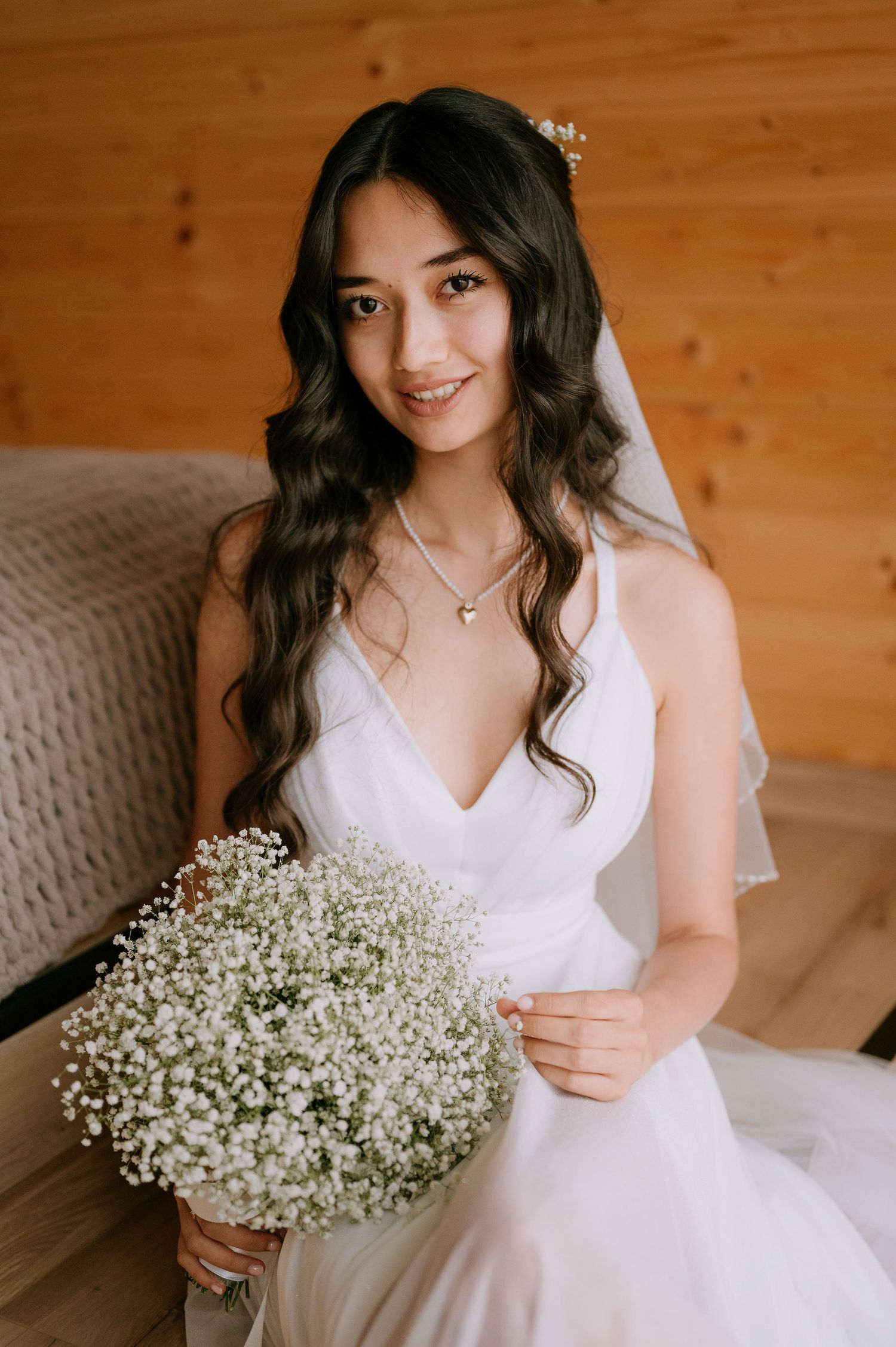 Romantic bridal portrait series with baby's breath bouquet and white gown in natural light setting.
